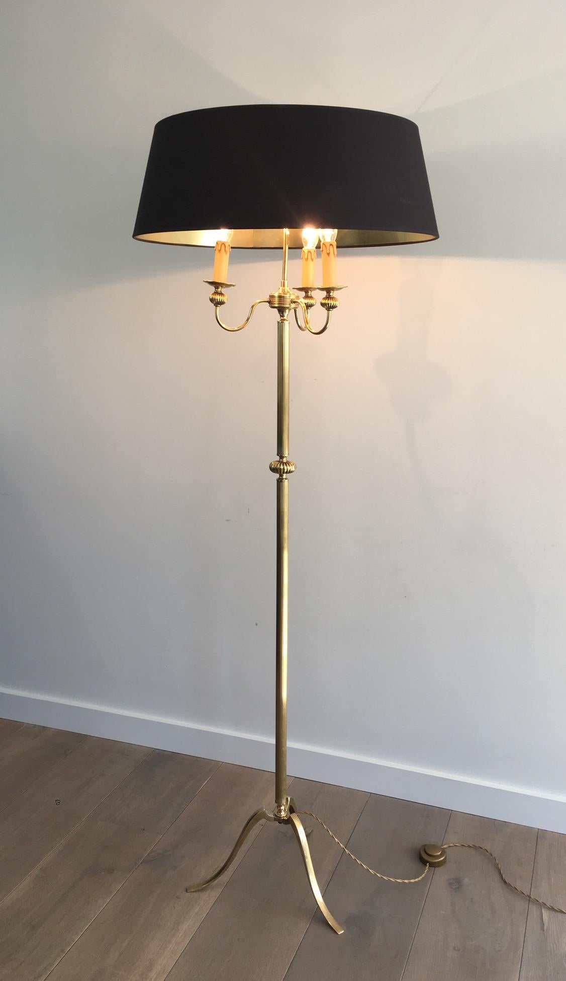 This neoclassical floor lamp is made of brass. It has 3 lights and a new shade made of black shintz gilt inside. This is a French work, in the style of so famous Maison Jansen, circa 1960.