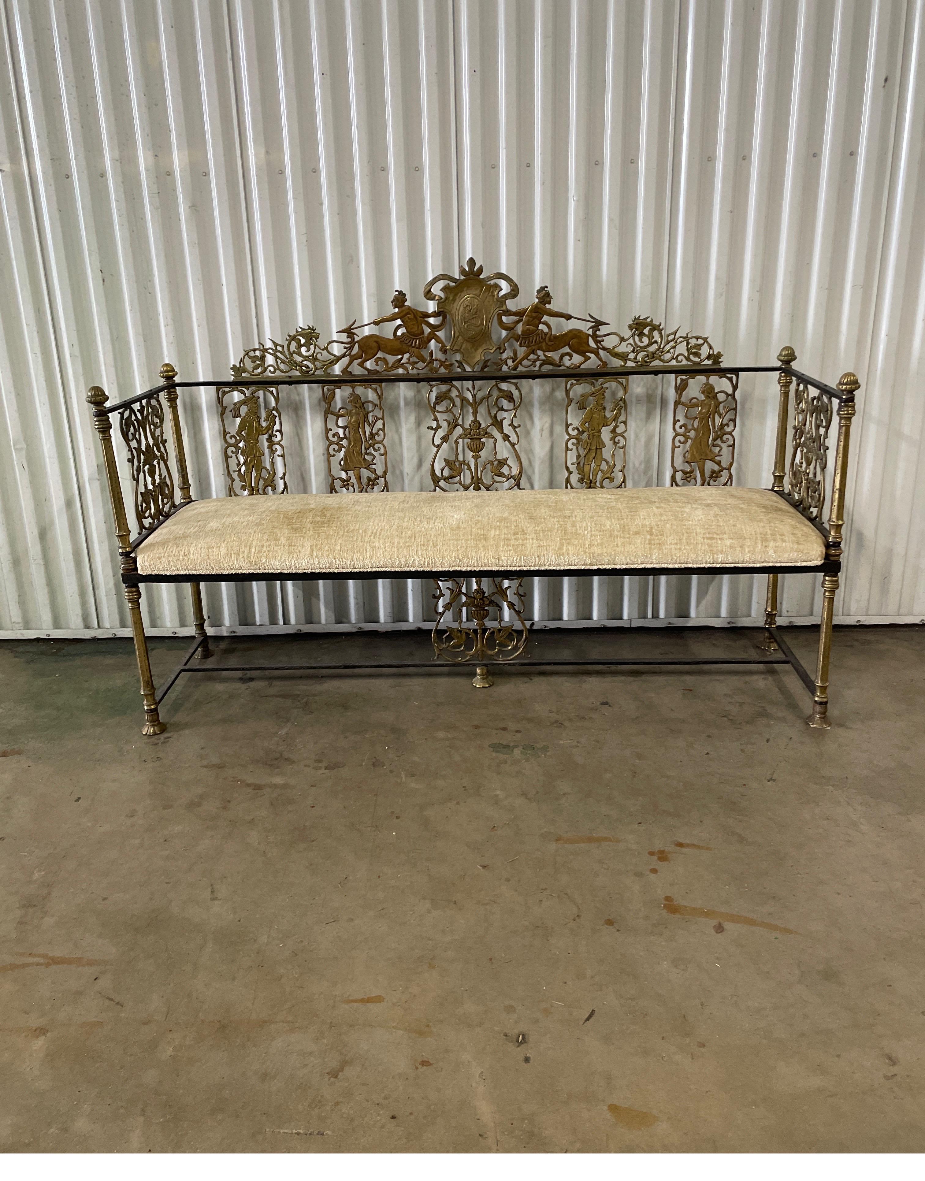 Highly unique brass & wrought iron neoclassical figural bench. This stunning bench is adorned with a dragon center crest surrounded by warriors & lions representing strength. The backrest is articulately detailed with both female & male figures.