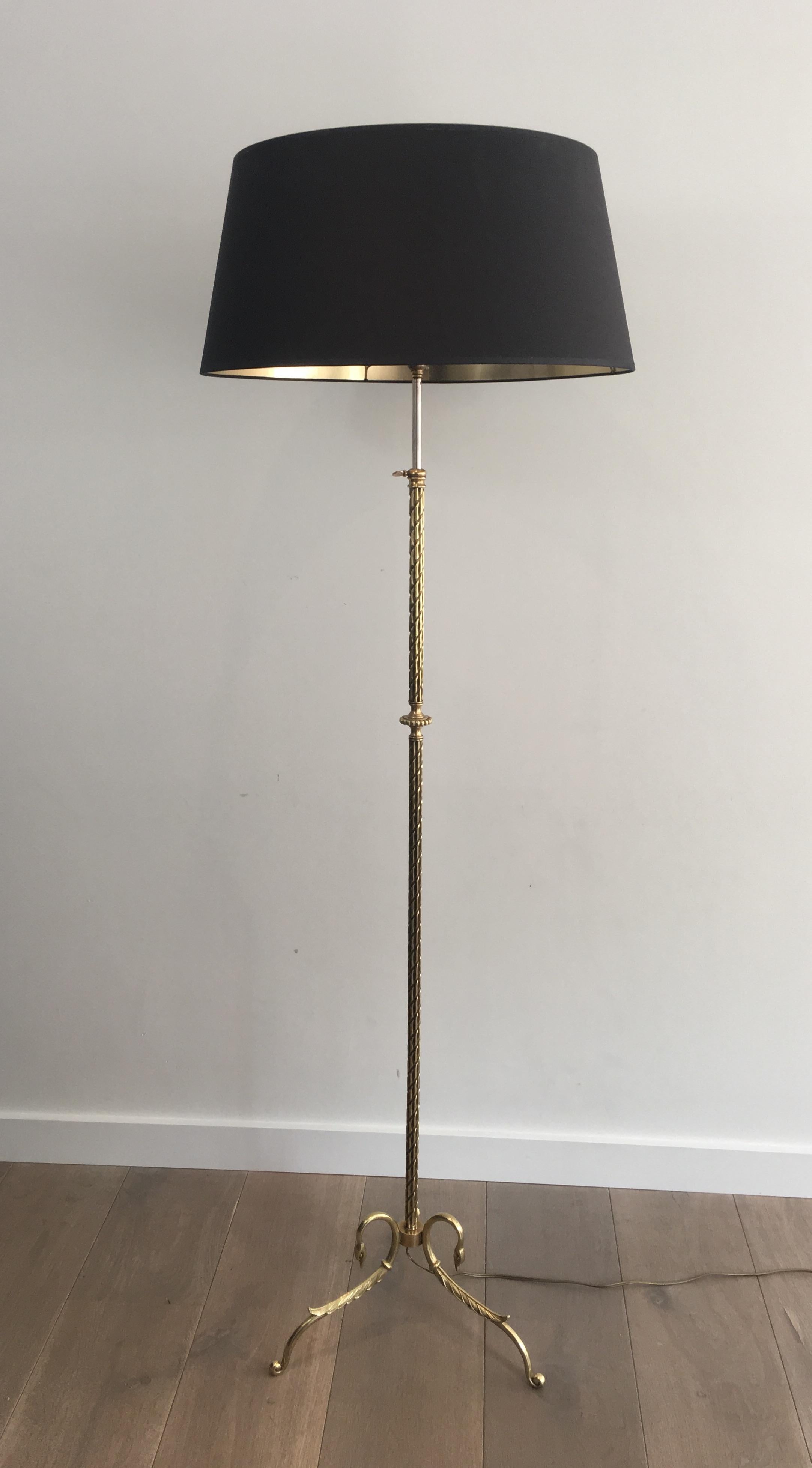 This neoclassical floor lamp is made of bronze and brass. The base is beautiful, chiselled and decorated with swanheads, the main part is chiselled and richly decorated as well and the floor lamp is adjustable. The shade has been remade with a black