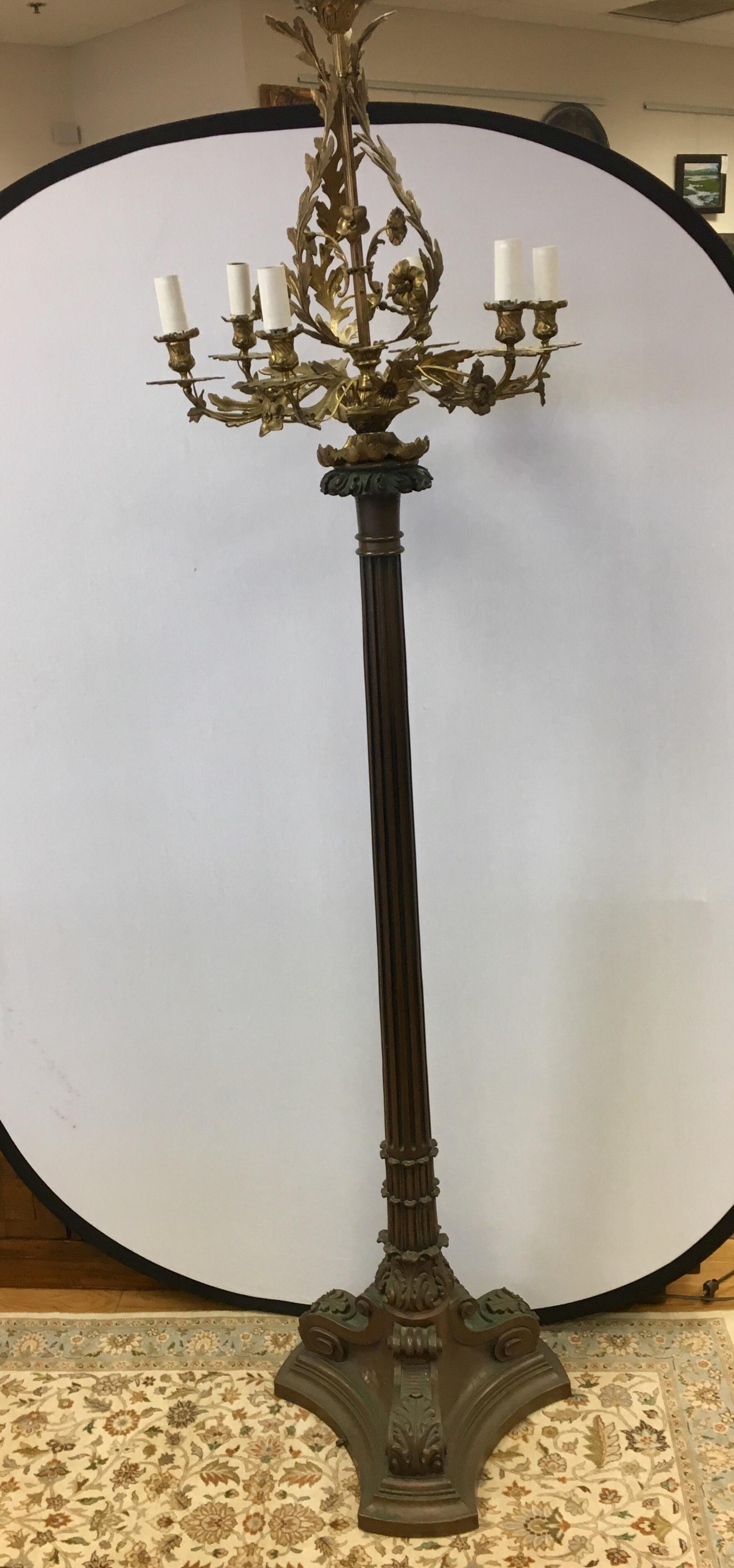 A stunning bronze chandelier was attached to a floor lamp and, voila, this neoclassical candelabra floor lamp was born. Turn of century and circa New England.