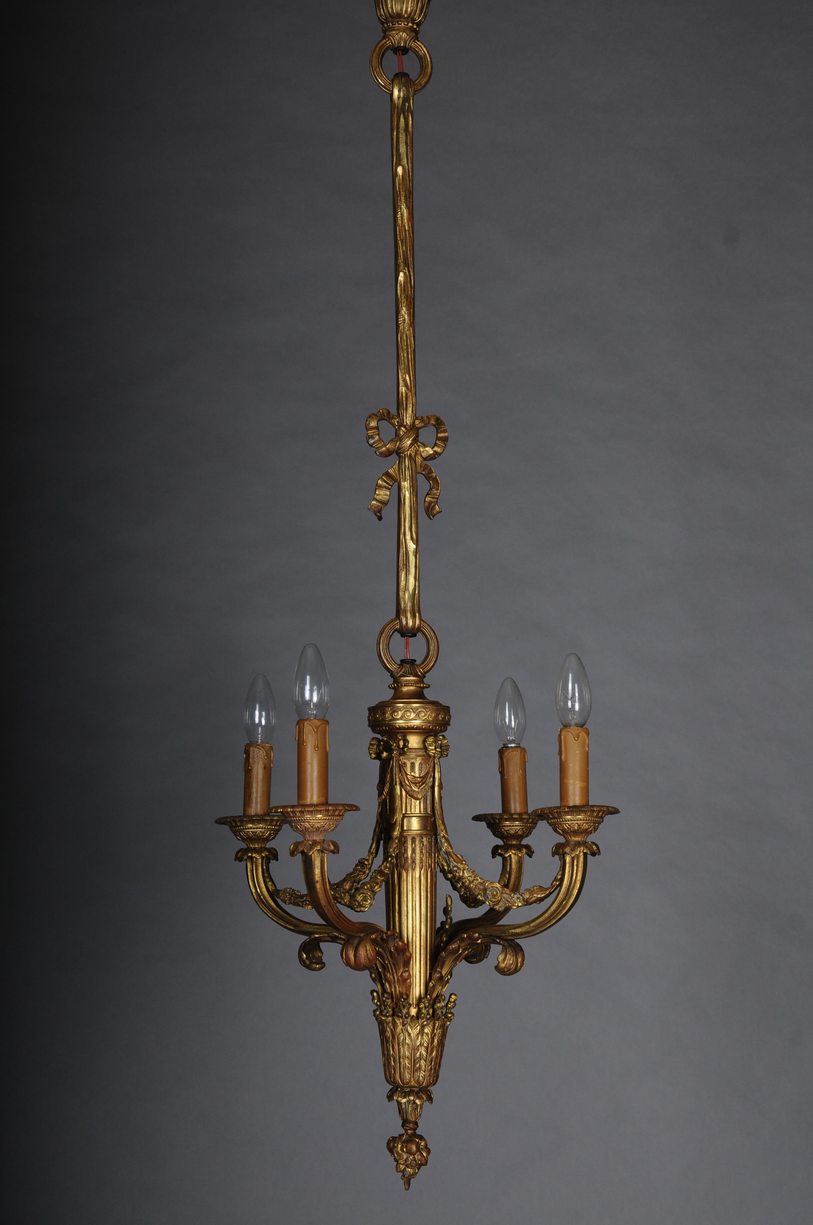 Neoclassical bronze chandelier, gilded.

Solid bronze, finely chiseled and gilded.

Four lights, each with an E14 bulb.

Fluted shaft, decorated with garlands and acanthus leaves. Curved light arms terminate in ornate spouted plates.

Electrified