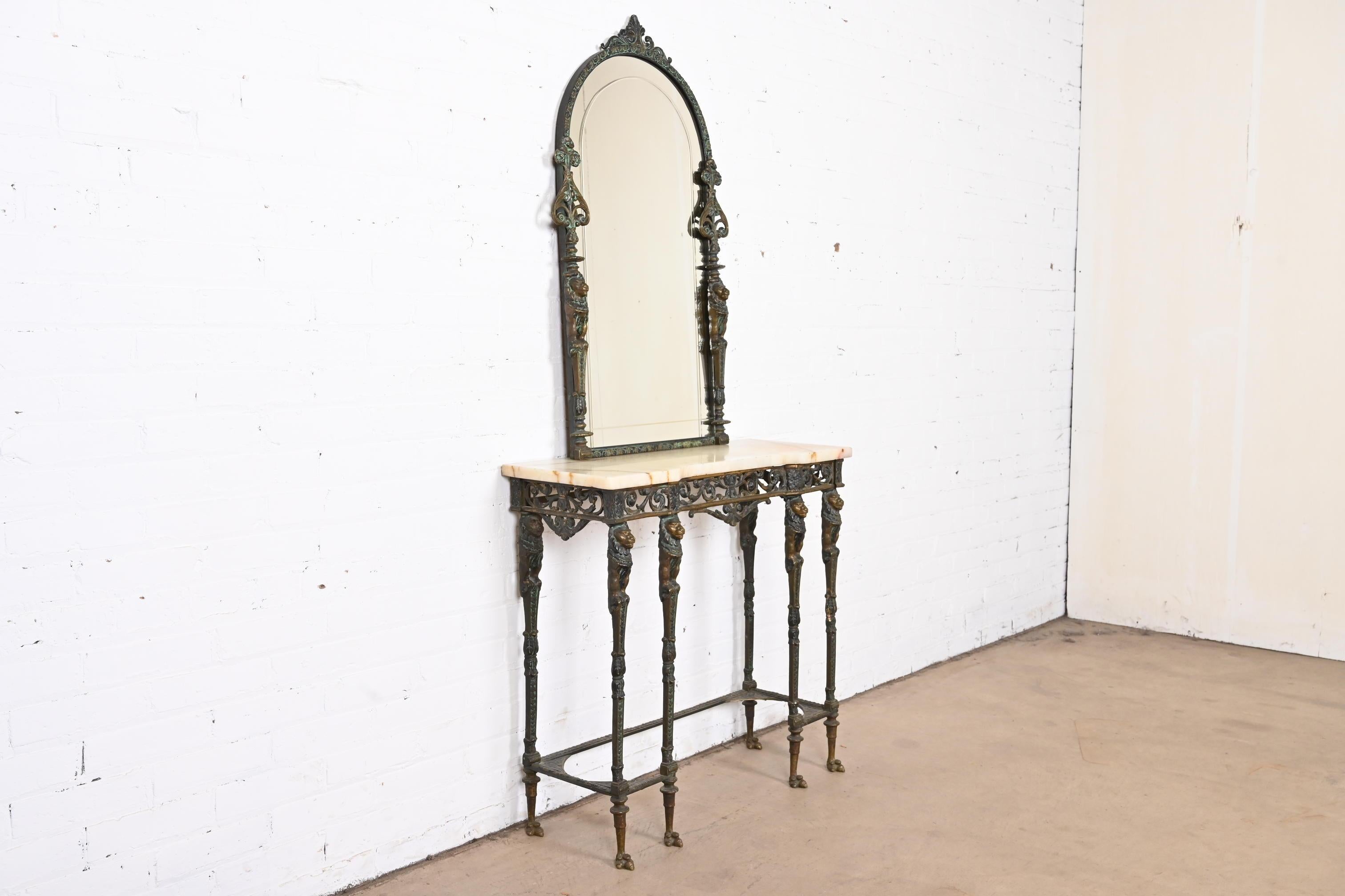 A gorgeous neoclassical or Empire style console table and wall mirror

Attributed to Oscar bach

USA, early 20th century

Stunning forged bronze with lion figures, marble top, and etched glass mirror.

Measures:
Table - 31