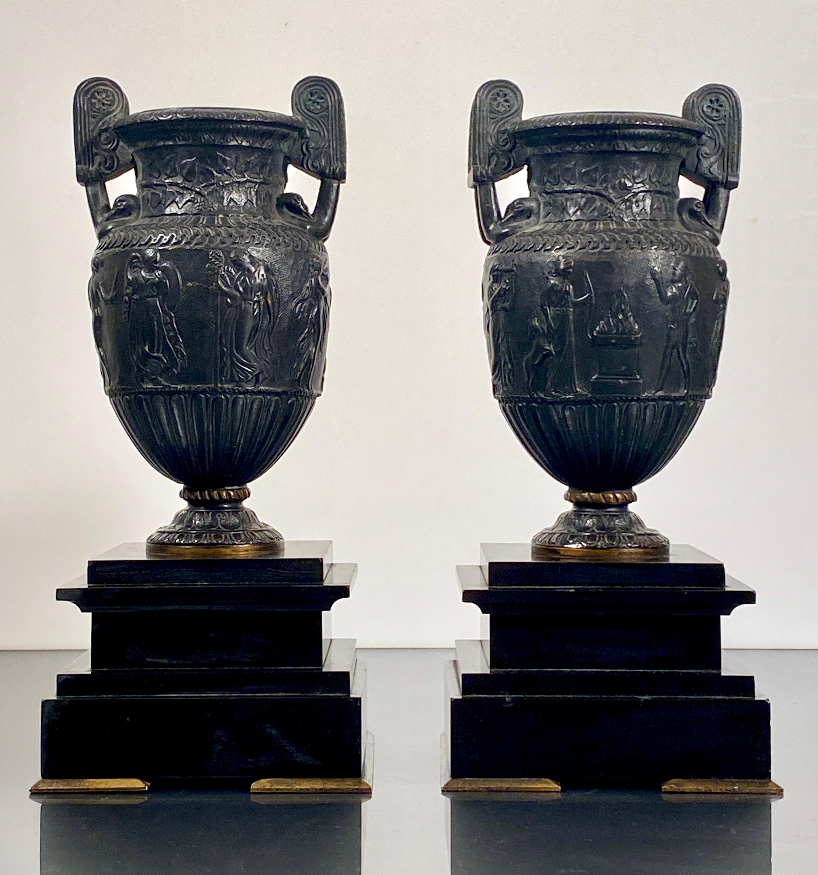Bronze Sosibios Volute Urns on Slate Plinths

A pair of French bronze Sosibios volute krater neo classical urns.
Beautiful classical design with each vase is of krater form with a bas-relief figural frieze decoration depicting Artemis and Hermes and