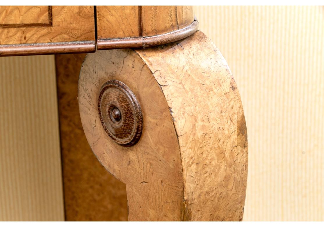 Console néoclassique en ronce de bois particulièrement fine, avec plateau en marbre noir panaché. Le dessus a des coins arrondis lisses, l'avant et les côtés, le dos est brut de décoffrage. La console comporte un seul tiroir avec une tirette en