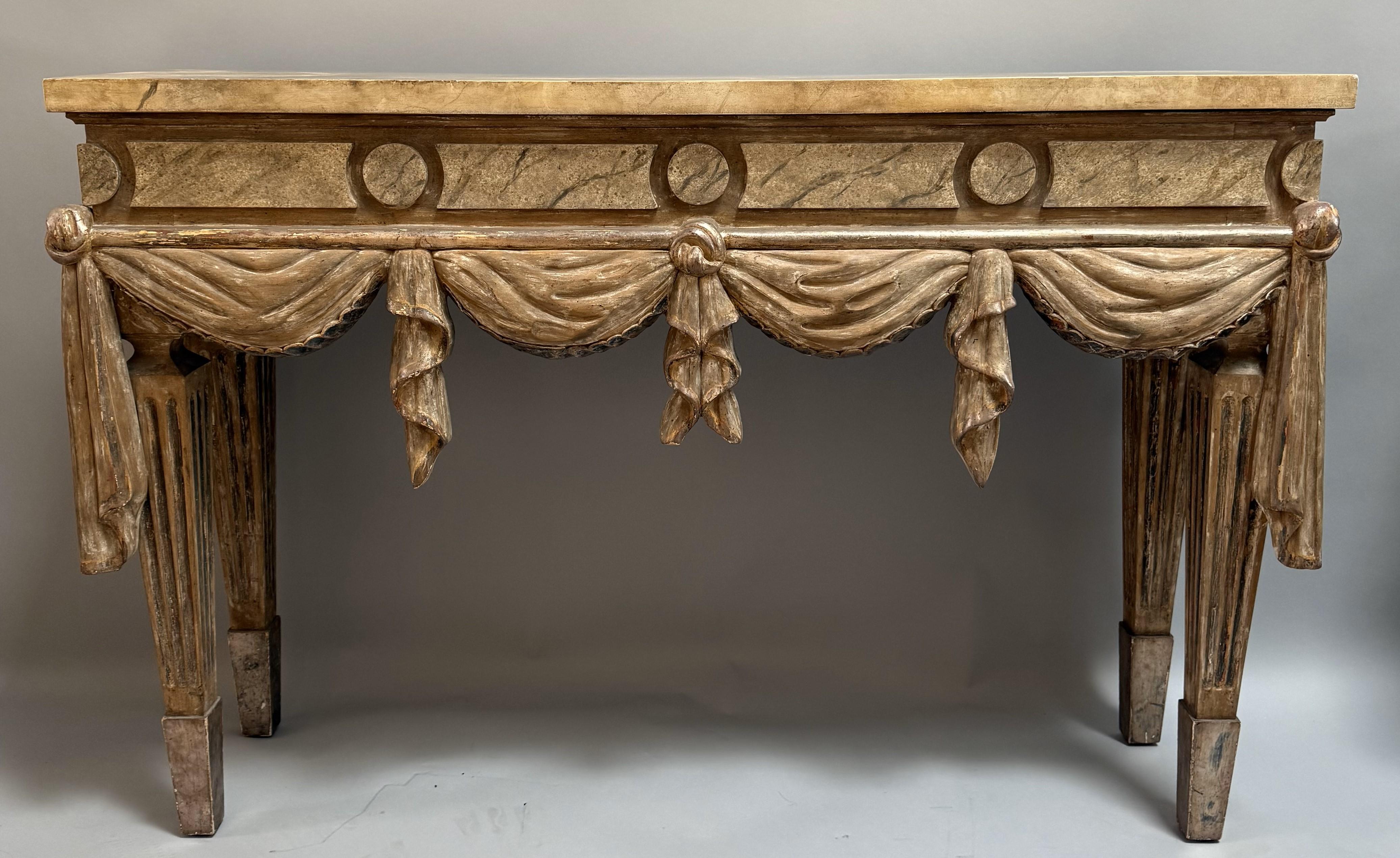 Consola italiana neoclásica tallada y pintada. La parte superior está pintada de imitación para que parezca mármol, y el frente está tallado, dorado y pintado para que parezca tela drapeada con patas estriadas. Muy buenas proporciones. Fabricado en