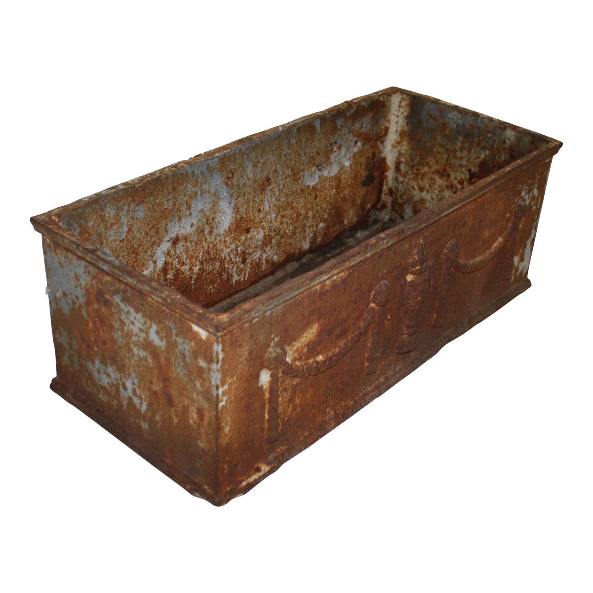 This rectangular, cast iron planter features an urn and swag motif on the front and back. Perfect for outdoor or indoor use. Two drain holes.