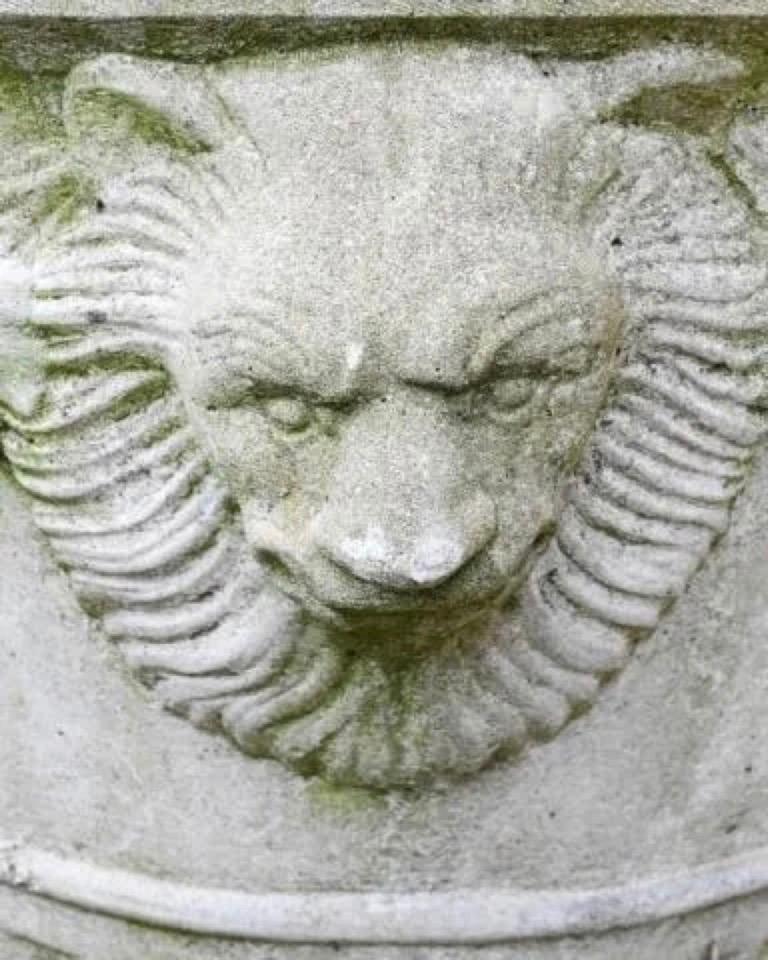 Wonderful vintage cast stone planter in the Neoclassical style having lion head in relief accompanied by fruit garland decoration. 
The urn has a hairline crack that has been sealed to prevent further cracking from exposure to elements.
 