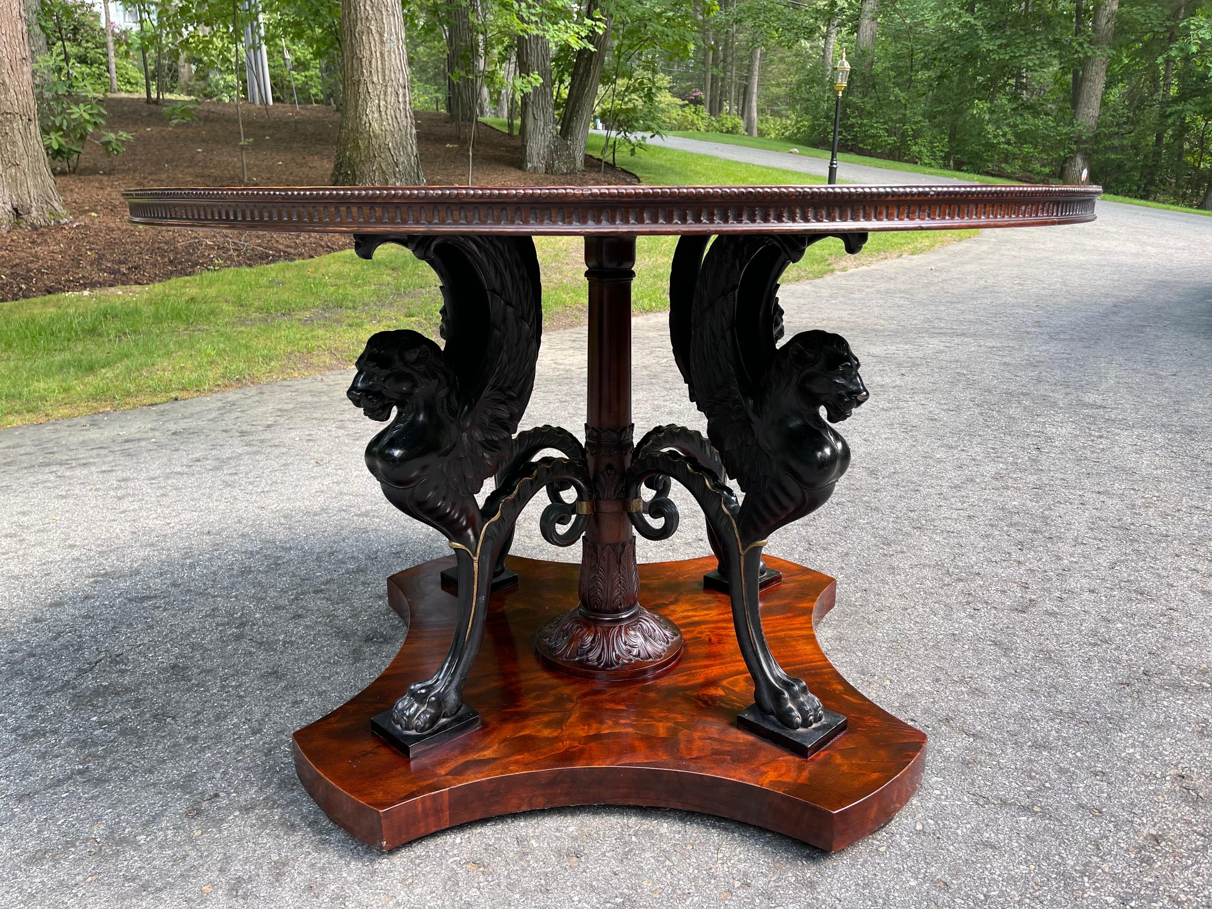 A rare English Neoclassical center table. Resting on a raised pedestal four finely carved winged lion griffins support a magnificent book matched Mahogany top. 
The Quality and craftsmanship is hard to find.
 