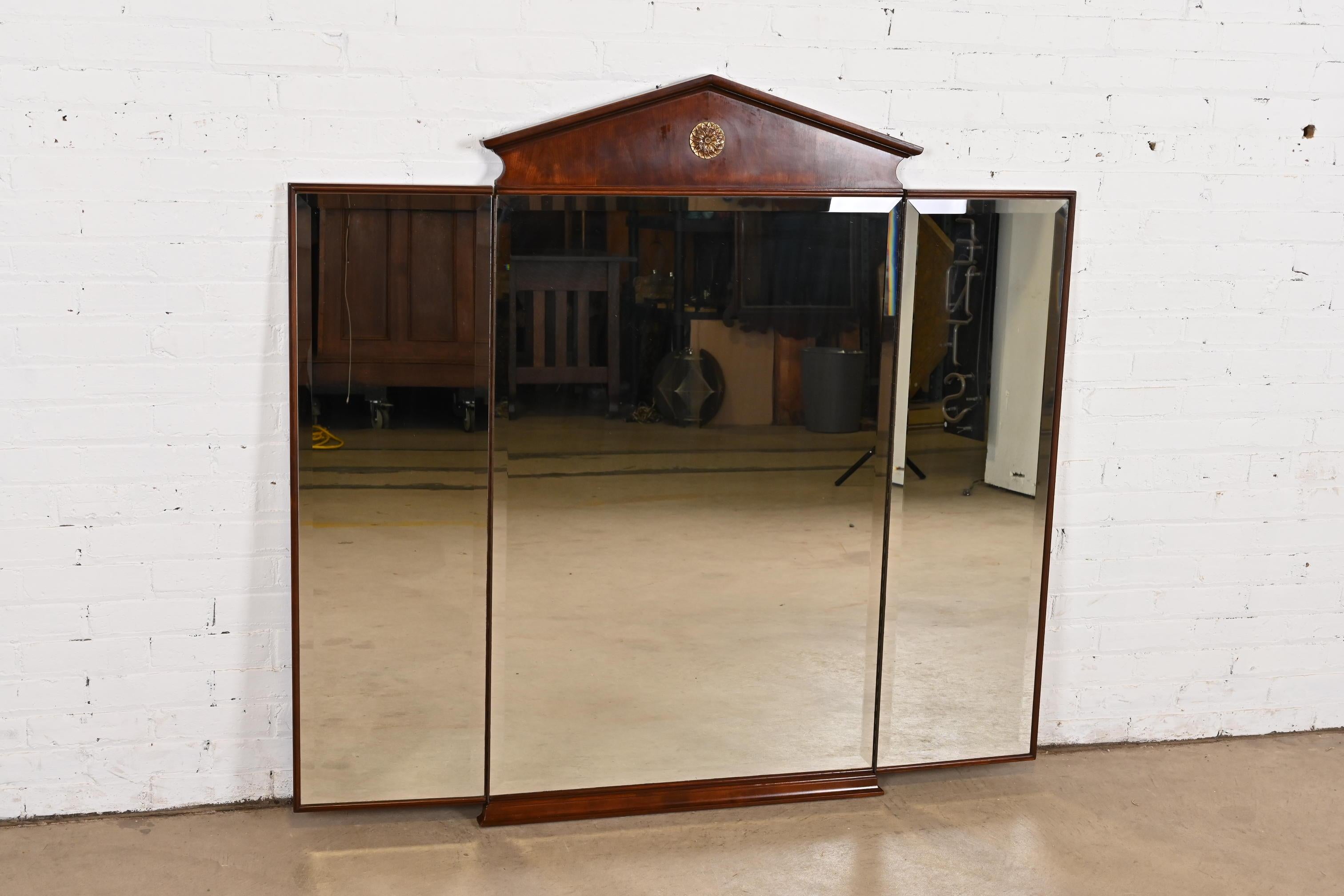 An exceptional Neoclassical or Empire style tri-fold mirror

USA, Late 20th Century

Solid cherry wood frame, with mounted brass ormolu, and beveled glass mirror.

Measures: 56