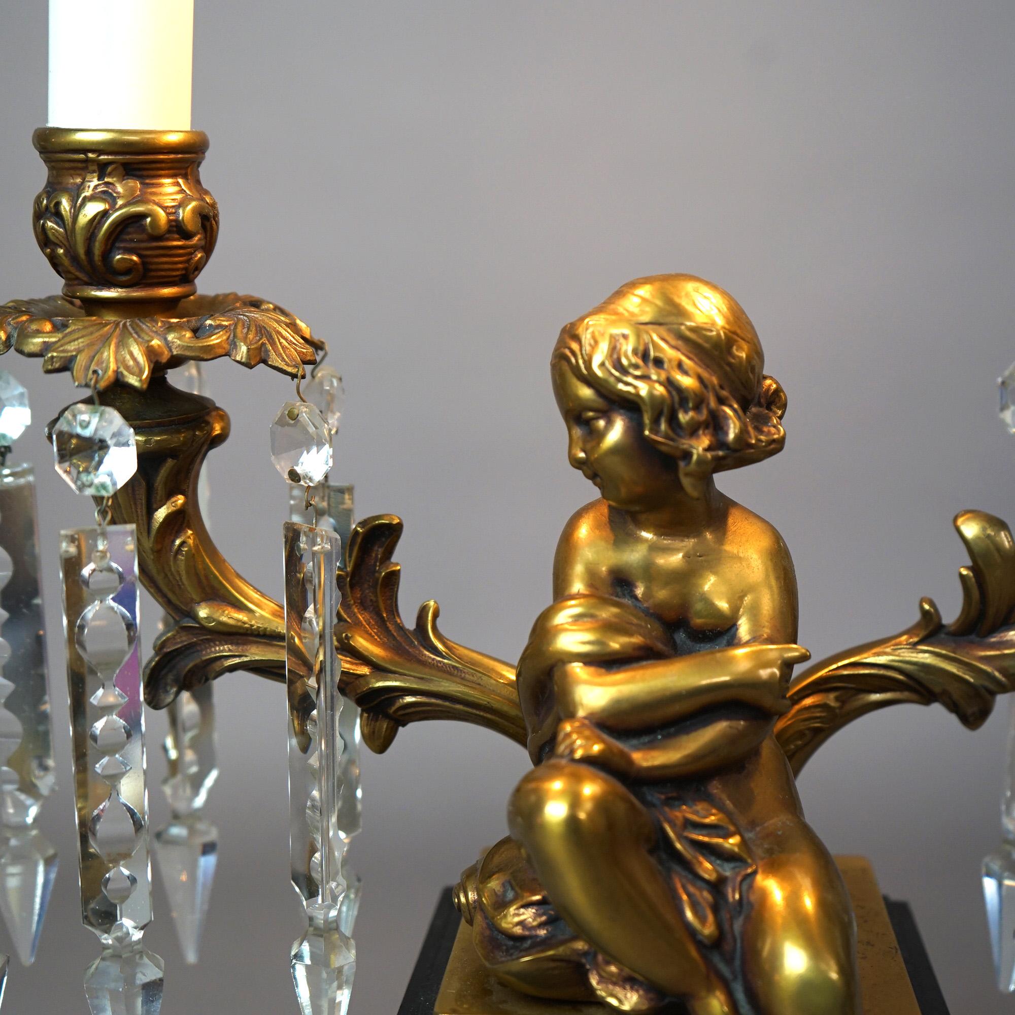 Métal  Lampe de table néoclassique à deux bras en laiton et métal ébonisé avec figurine de chérubin 20e siècle en vente