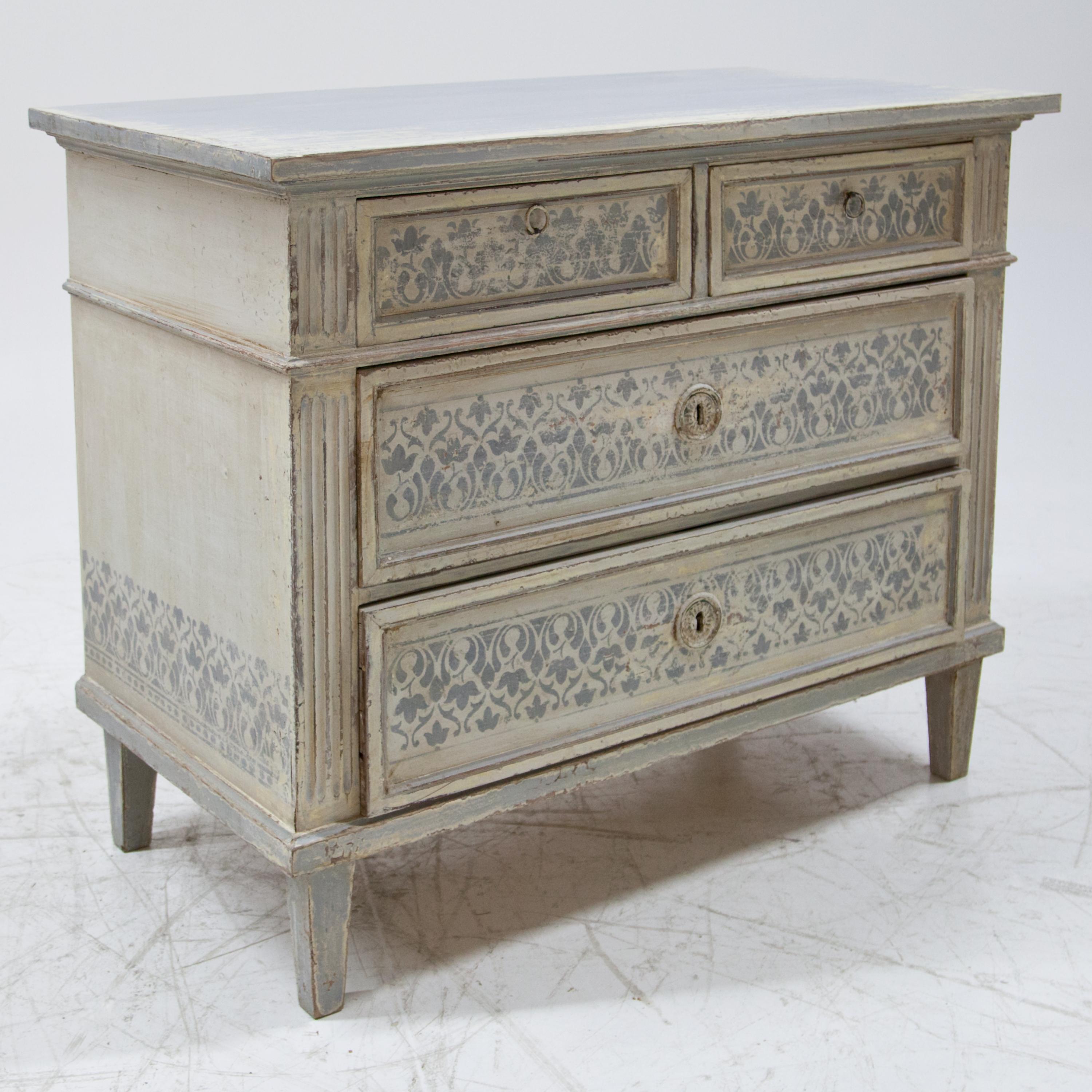 Chest of drawers in cream and light blue on square pointed feet with fluted corners and two large and two smaller drawers. The setting is new and decoratively rubbed through.