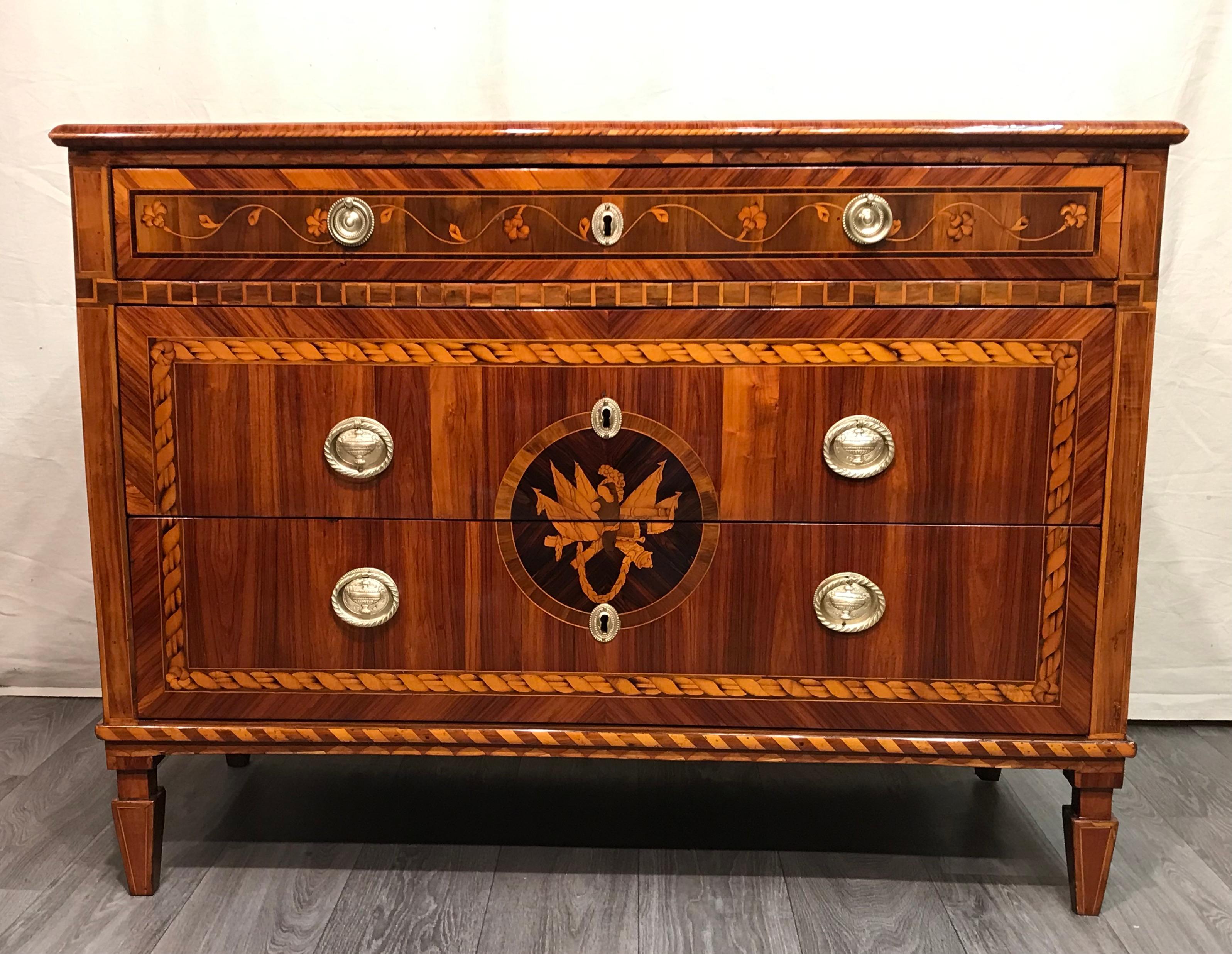 Neoclassical chest of drawers, Italy 1780.
This exquisite chest of drawers has a pretty kingwood veneer and and exquisite marquetry in satin wood and other prestigious woods. The three drawers have a connected marquetry design. The top drawer is