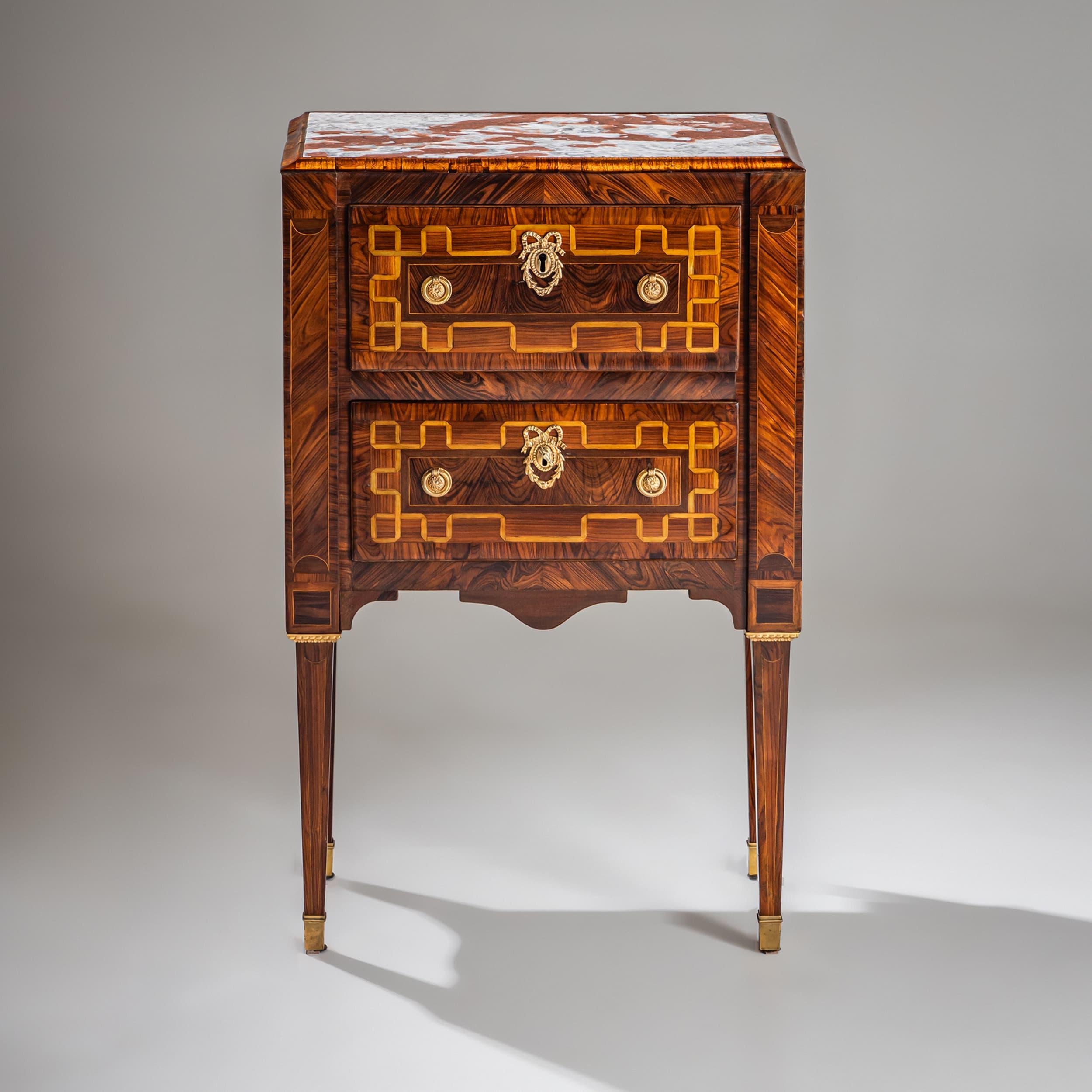 Elegante cassettiera neoclassica a due cassetti proveniente dall'Italia, realizzata intorno al 1800. La cassettiera poggia su gambe quadrate appuntite con sabot in ottone e ha una struttura curva. Il motivo dell'impiallacciatura è impressionante con