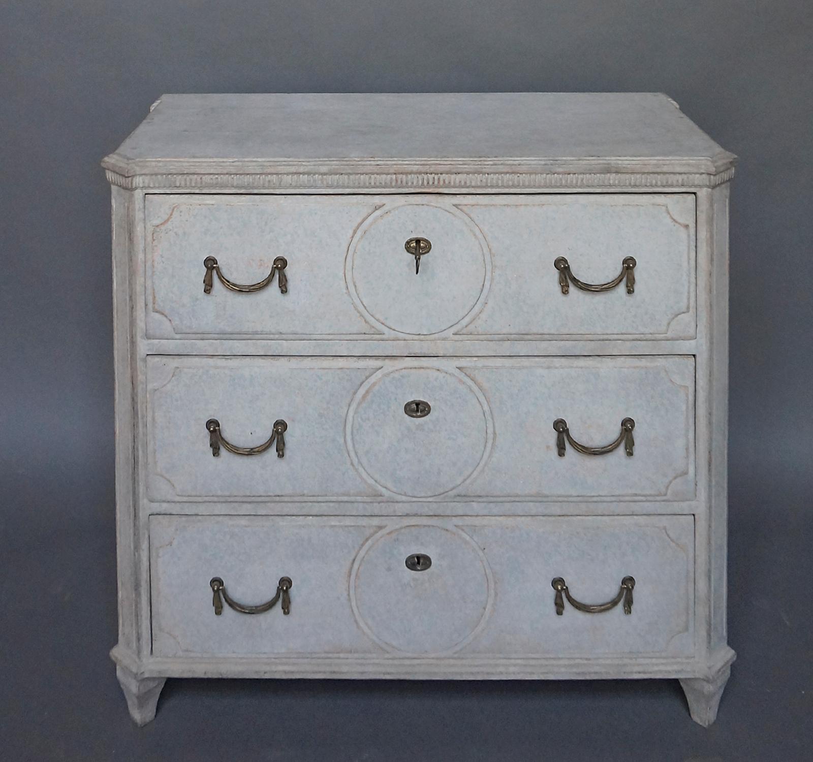 Neoclassical chest of drawers, Sweden circa 1890, with shaped panels in each drawer front, interrupted with incised circles. Shaped top with dentil detail, canted corners, and brass handles with swagged ends.