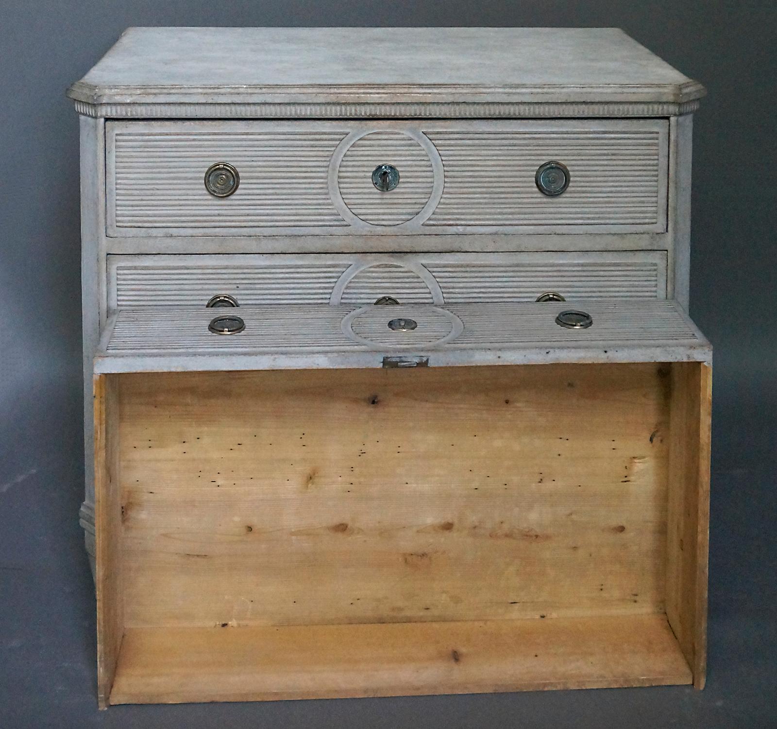 Swedish neoclassical chest of drawers, circa 1860, having reeded drawer fronts with recessed circles around the escutcheons. Shaped top with canted corners and unusual molding. Brass hardware, tapering square legs.