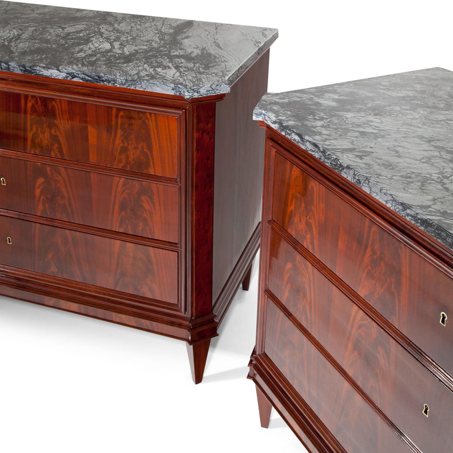 Pair of Italian chests of drawers, standing on tapered feet, with three drawers and a grey-white marble top. The trusses are profiled as are the upper and lower edges. The corners are slanted and accentuated. Very beautiful mahogany veneer pattern.