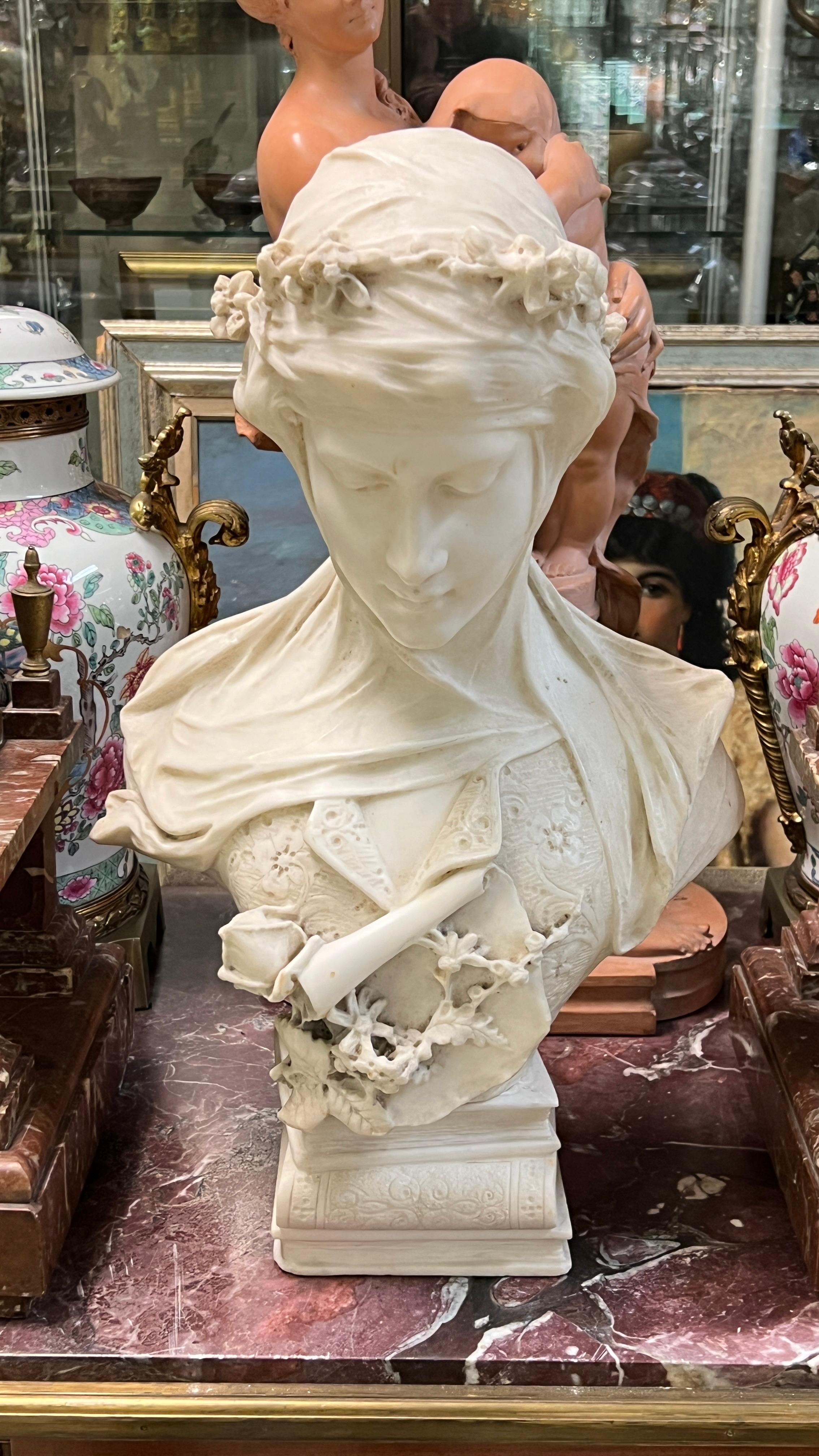 Buste en marbre blanc du XIXe siècle représentant une belle femme de style Renaissance, drapée d'un voile, portant une couronne de guirlandes florales avec un bouquet de fleurs sur le buste, et monté sur un piédestal de livres empilés.  