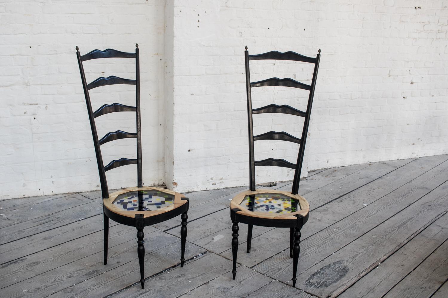The tall mosaiced chairs are in their style similar to the chairs of the famous designer Mackintosh who inspired many artisans at the beginning of the 20th century as this couple of antique chairs shows. The original sitting has been replaced with a