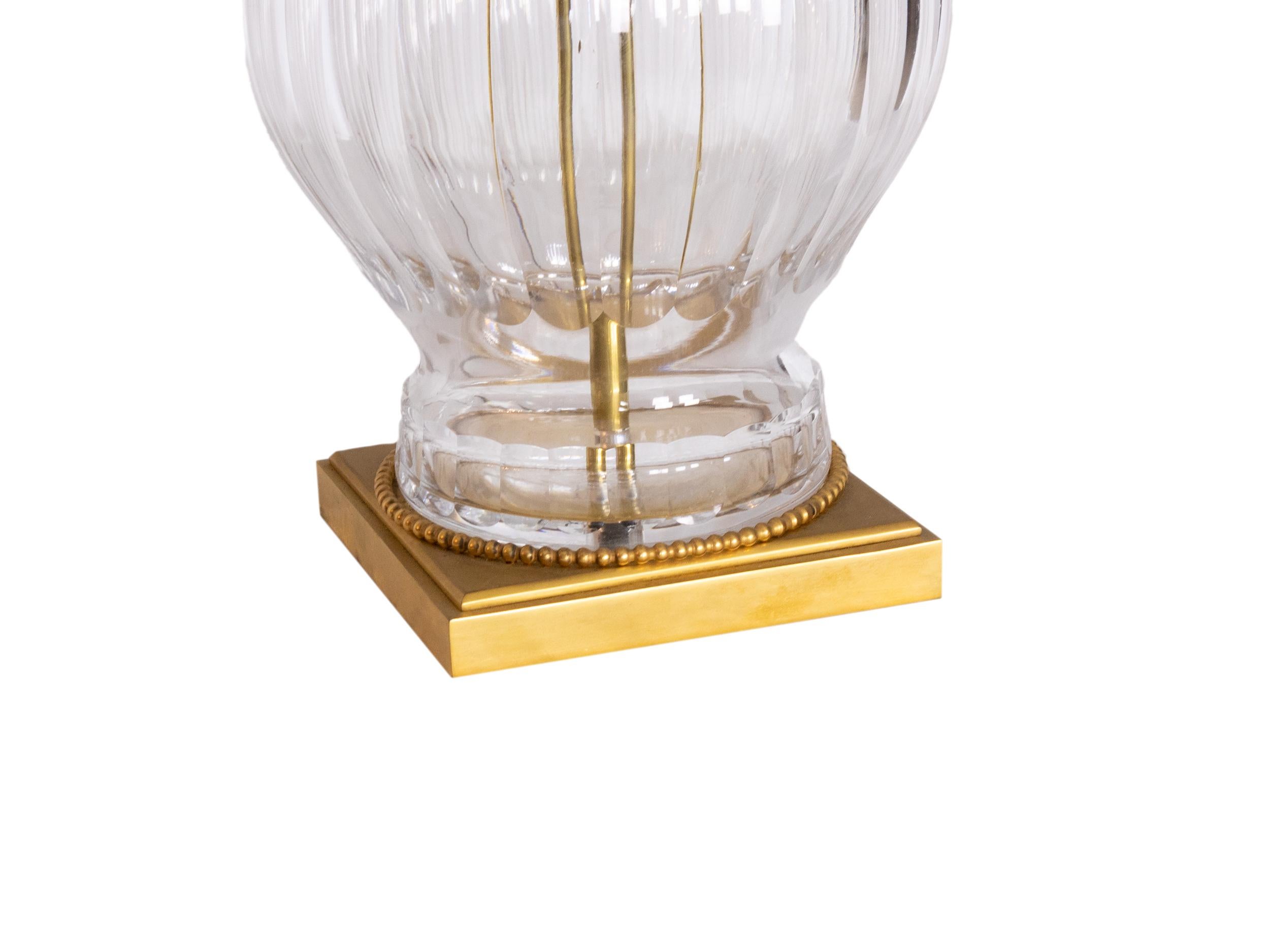 Lampe de table en cristal néoclassique du XXe siècle, inspirée par l'opulence du style Louis XV. Fabriqué en verre de cristal clair strié et orné de détails en bronze doré.

La forme généreuse comprend un abat-jour en forme de dôme et une base
