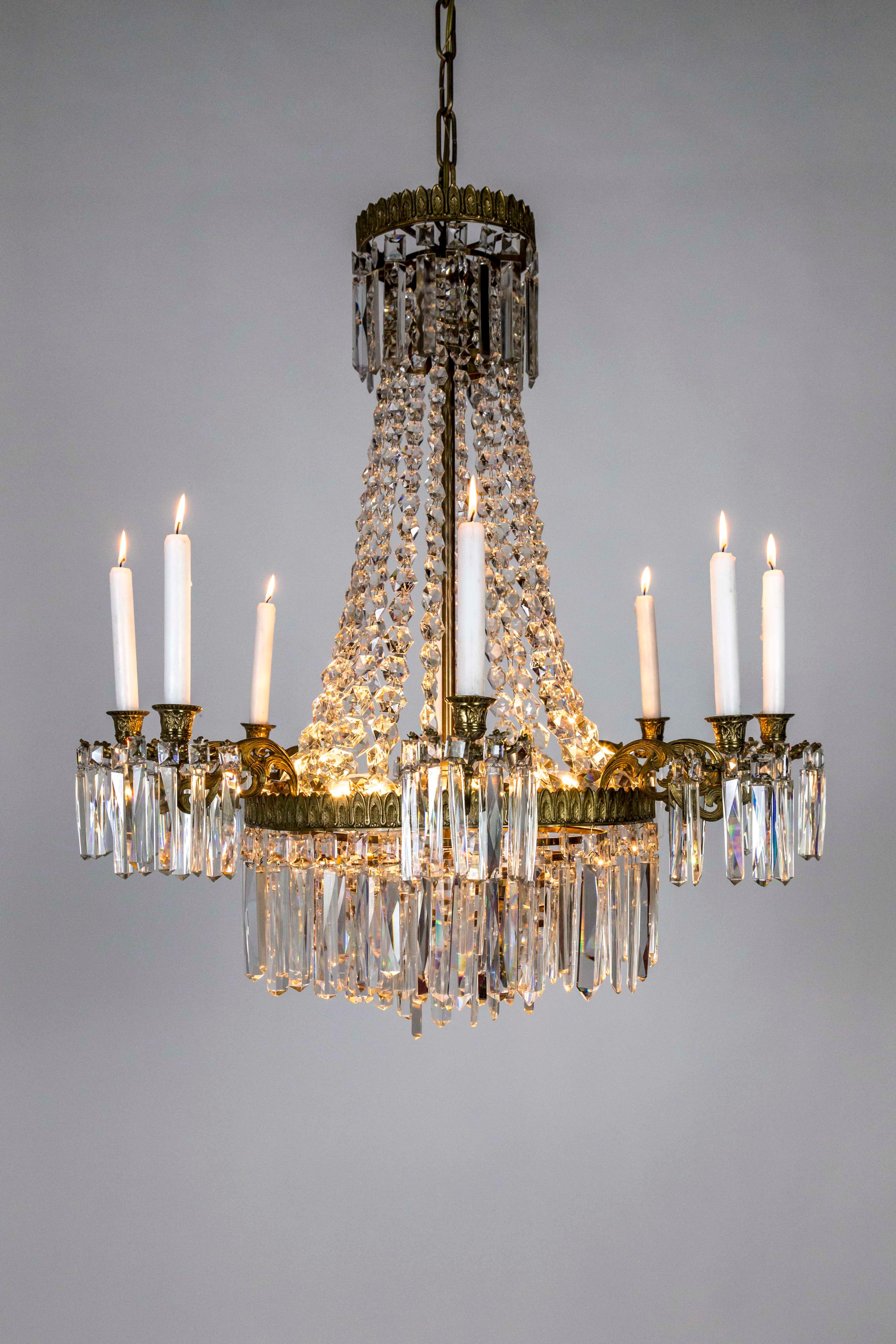 A French, neoclassical, crystal bead, tent chandelier with 8 candleholder arms and 8 sockets within the body of multi-tier rings. High quality, baguette, coffin crystals hang from the rings and pierced metal bobeches, circa 1910. Measures: 31