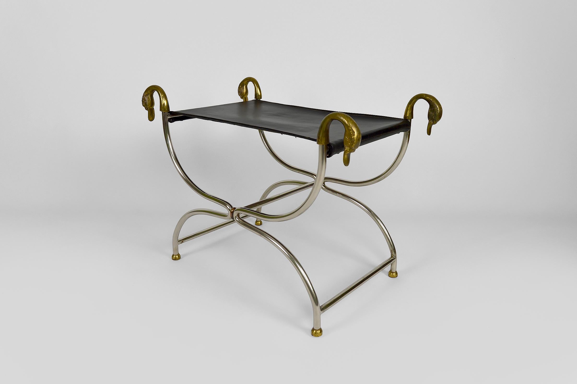 Elegant antique-style stool / curule with chromed metal structure ending in bronze or brass swan heads, and black leather seat.

Neo / Revival Classical style / Hollywood Regency, France, circa 1960-1970.
In the style of Maison Jansen