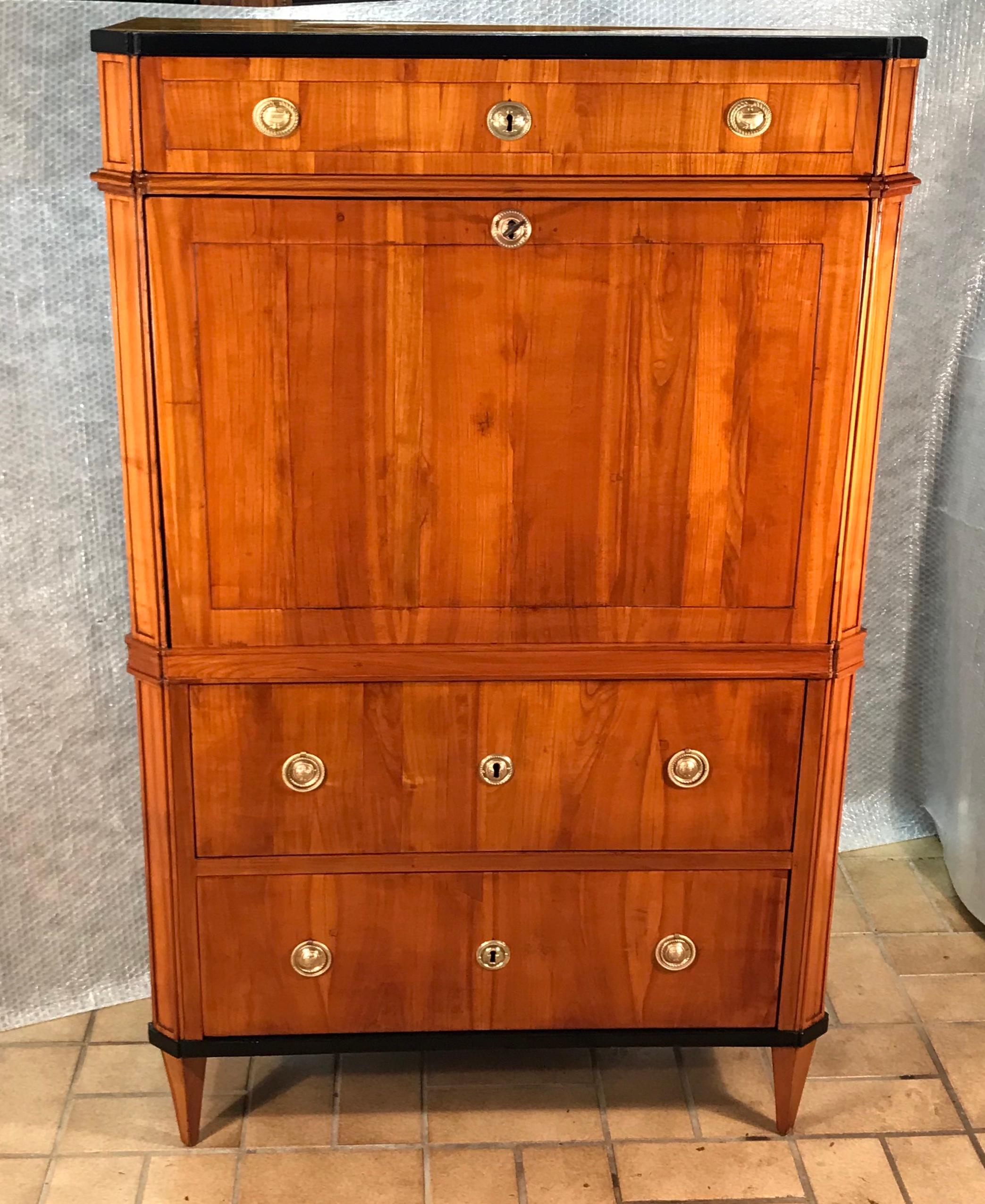 Exquisite drop front desk, Switzerland 1810-20, beautiful cherry veneer with ebonized details. The inside of the writing top has 12 small drawers and a central open compartment, which is decorated with a mirror and a checkered pattern floor. 
The