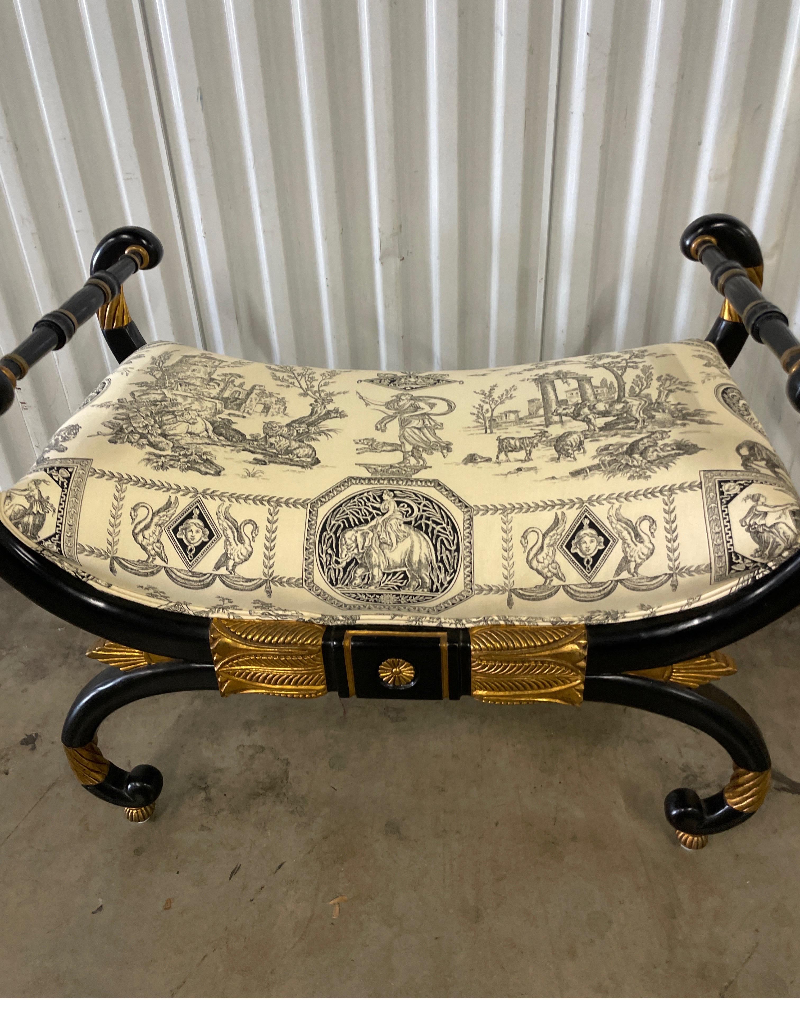 Striking vintage Neoclassical style ebonized and gilded bench by Baker Furniture Company. Beautiful newly upholstered seat cushion.