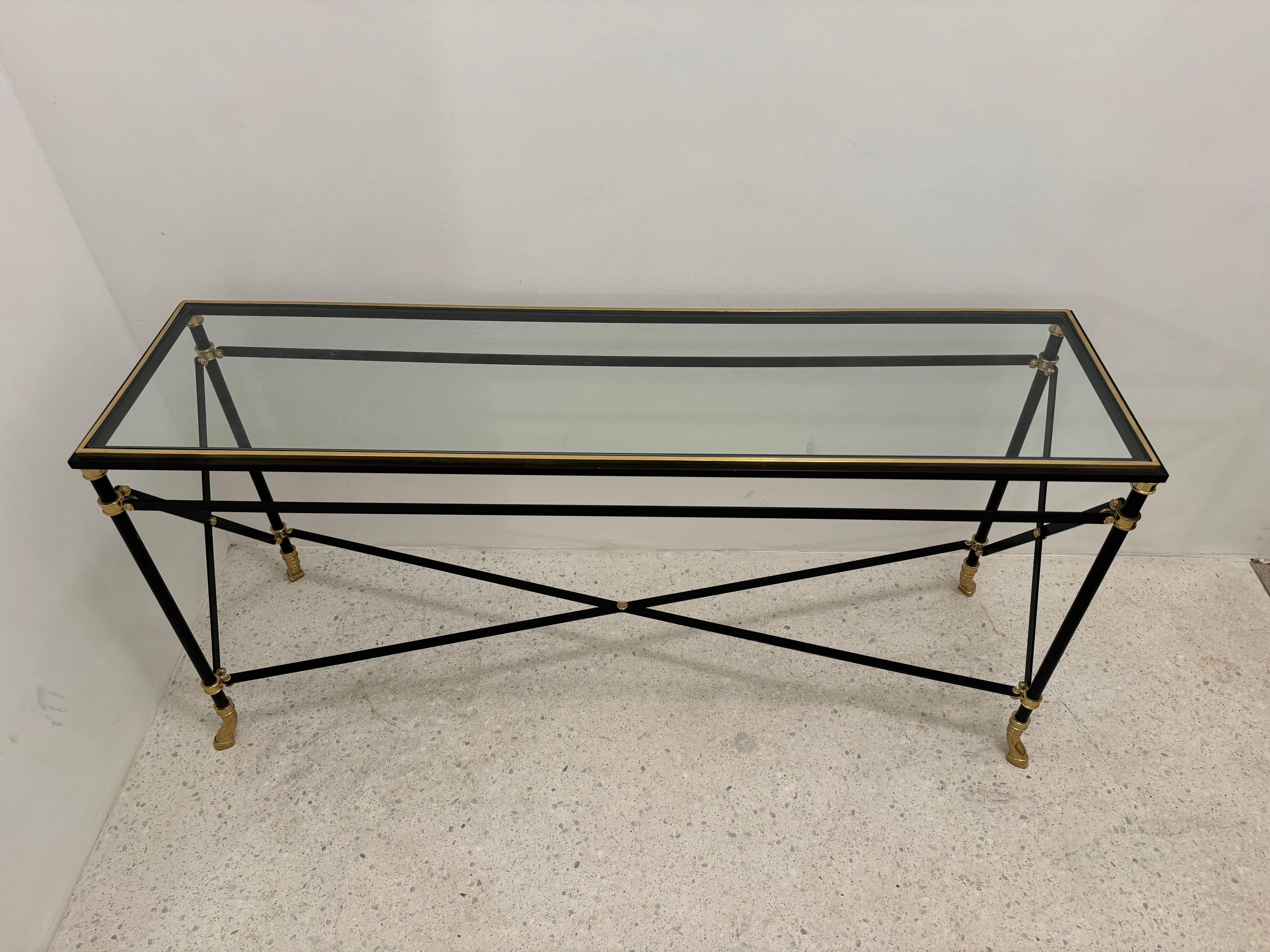 Mezcla sofisticada de elegancia neoclásica y refinamiento modernista, esta consola francesa de los años 70 es una auténtica pieza de diseño. Fabricada en hierro ebonizado con detalles en latón, la mesa presenta un marco lineal minimalista realzado