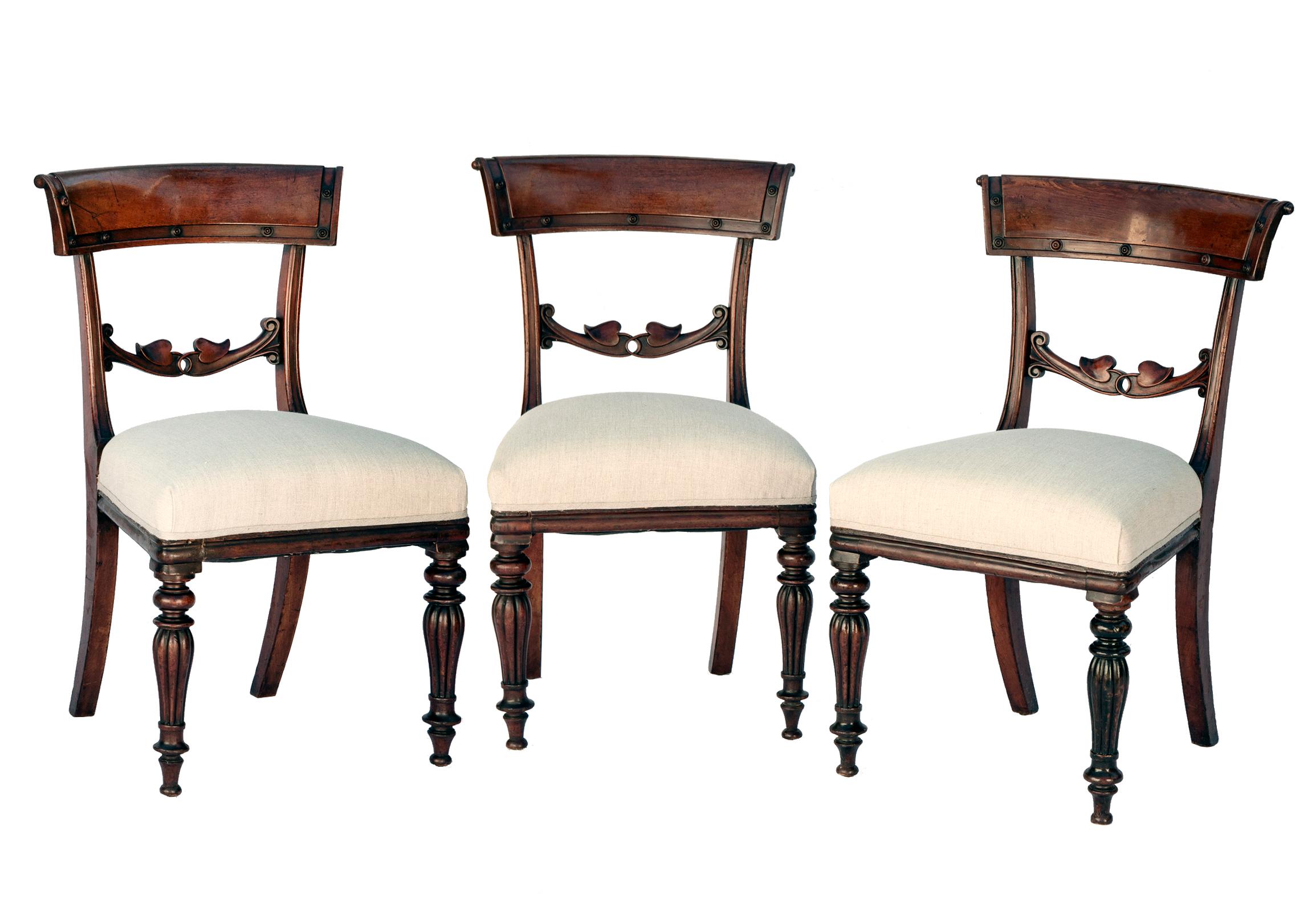 Exceptional set of six Neoclassical Klismos Empire period mahogany dining chairs fearing a dramatic polished finish in dark mahogany. The seats have been entirely reconstructed & covered in Belgian linen with self ribbon welting.
The chairs are