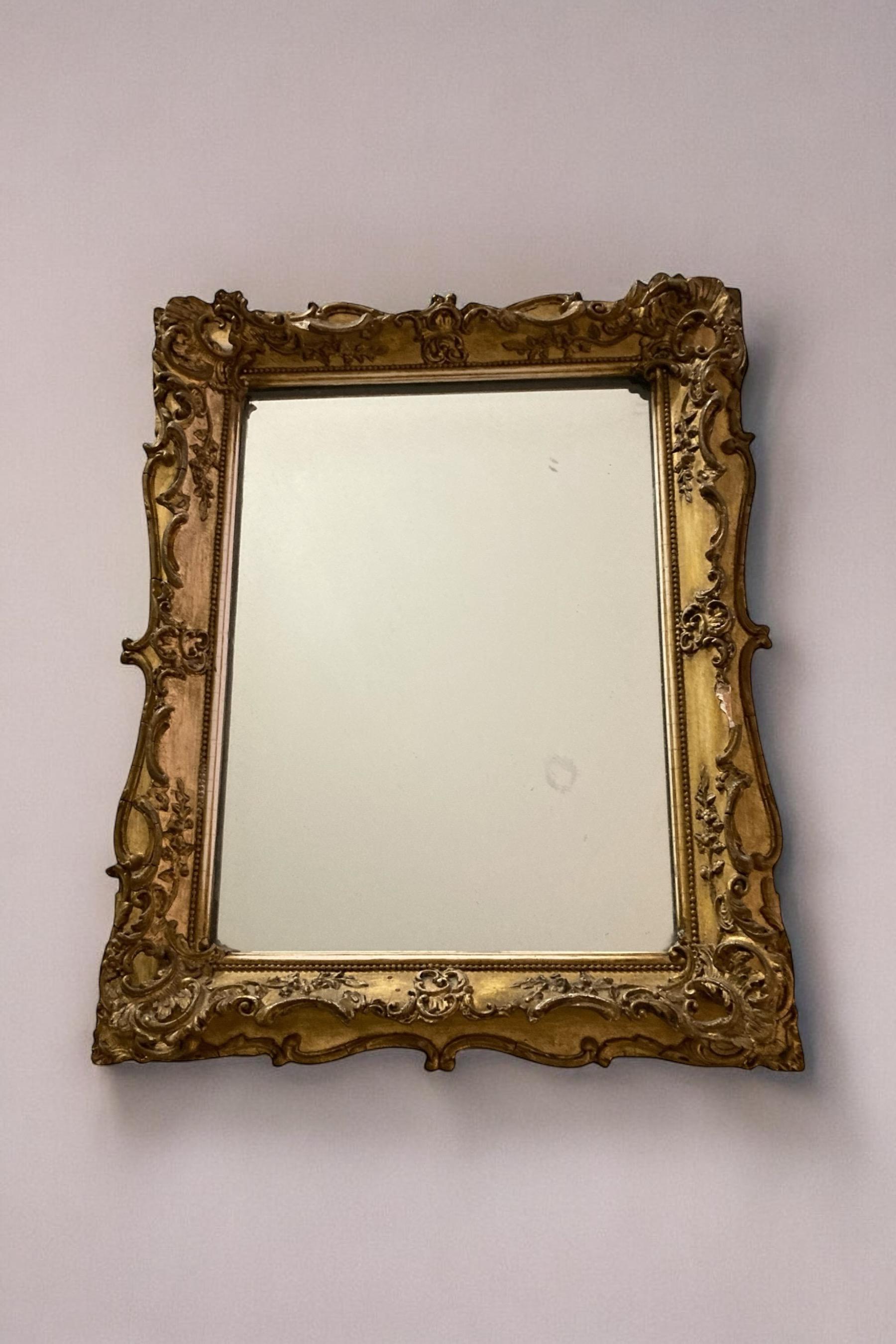 Rococo style gilt gesso rectangular wall mirror. Mild foxing to the glass which adds character and age. CIRCA Mid 1800's. Very small losses to the gilt frame which are unnoticeable to the eye.

W: 31cm

H: 38 cm

D: 3 cm