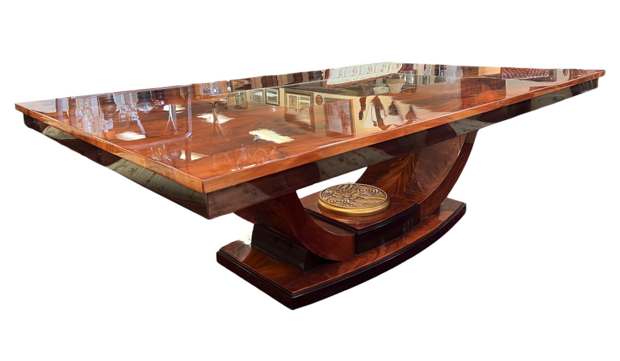 Introducing our magnificent English art deco-styled flame mahogany veneer dining table. Crafted from hardwood and finished in flame mahogany veneer, also known as crotch mahogany, this dining table boasts a stunning high-gloss finish that