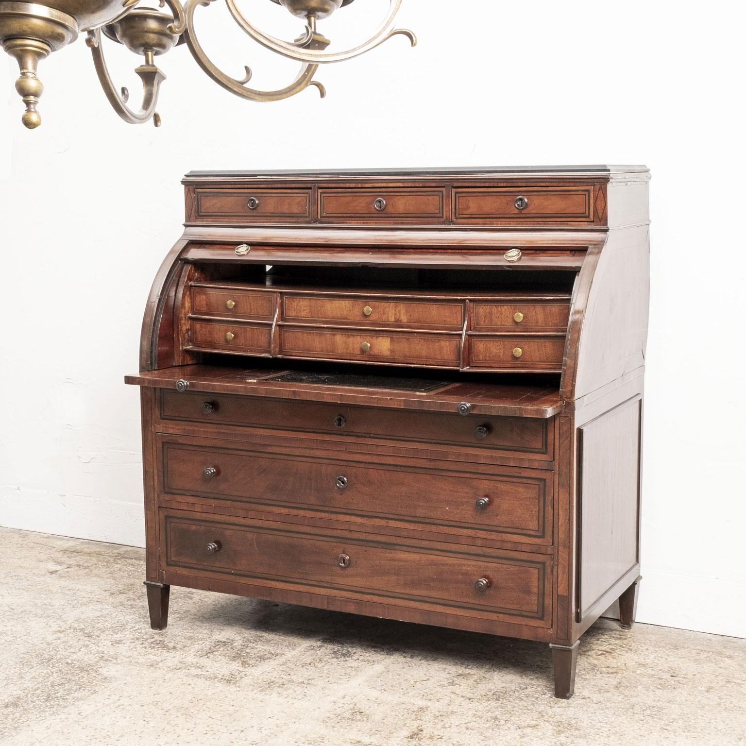 Neoclassical English mahogany secretary, circa 1820-1840, with roll-top and ebonized inlay. Secondary woods are English oak and fruitwood. Roll-top pulls are gilded brass and all other exterior pulls turned wood. Interior pulls are brass. Gilded