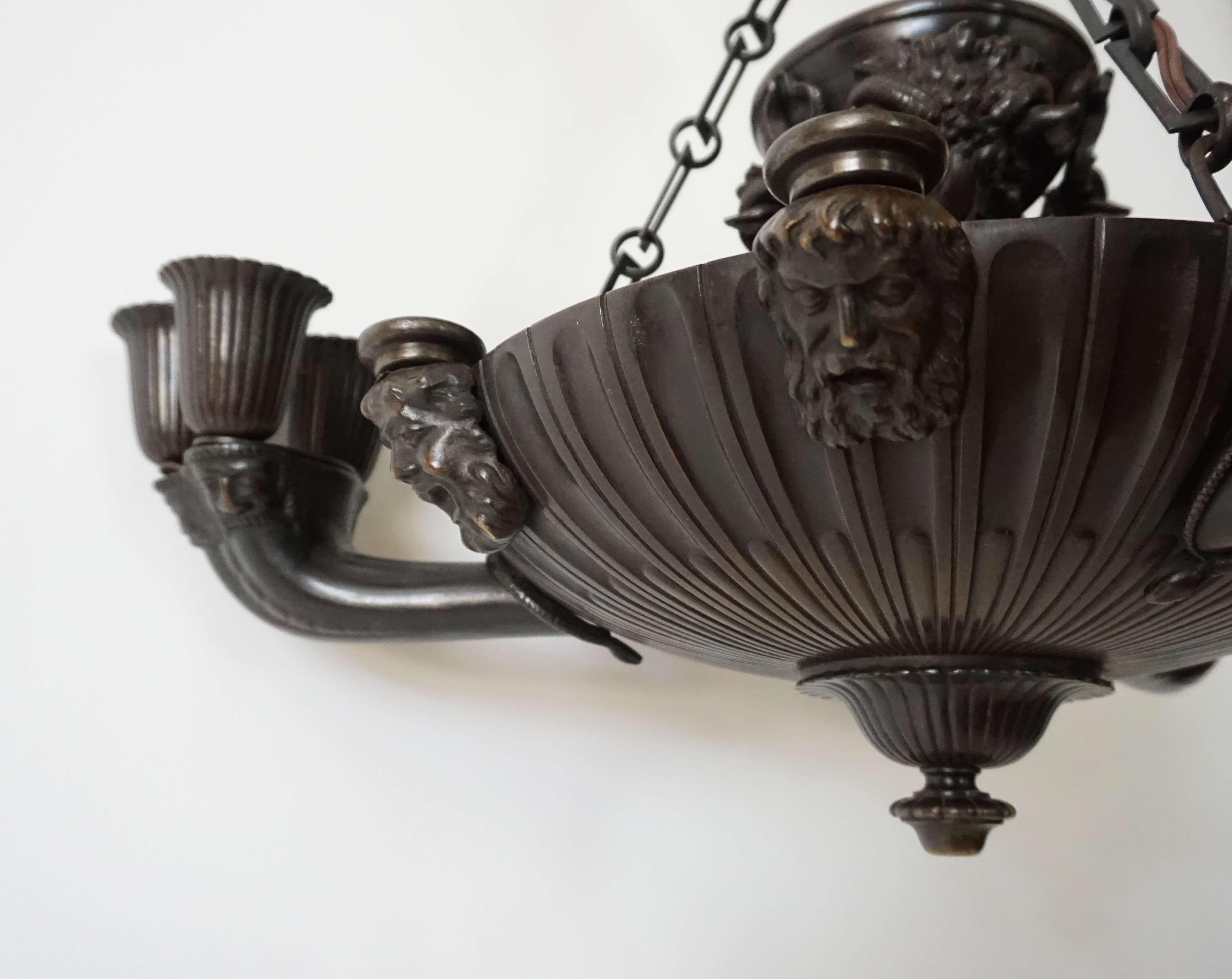 Elegant and rare circa 1825 English Regency George IV period solid patinated bronze chandelier in neoclassical 'Grecian' style having molded ceiling canopy issuing twist-stem standard joining gadrooned lambs tongue 'collar' connecting chains to