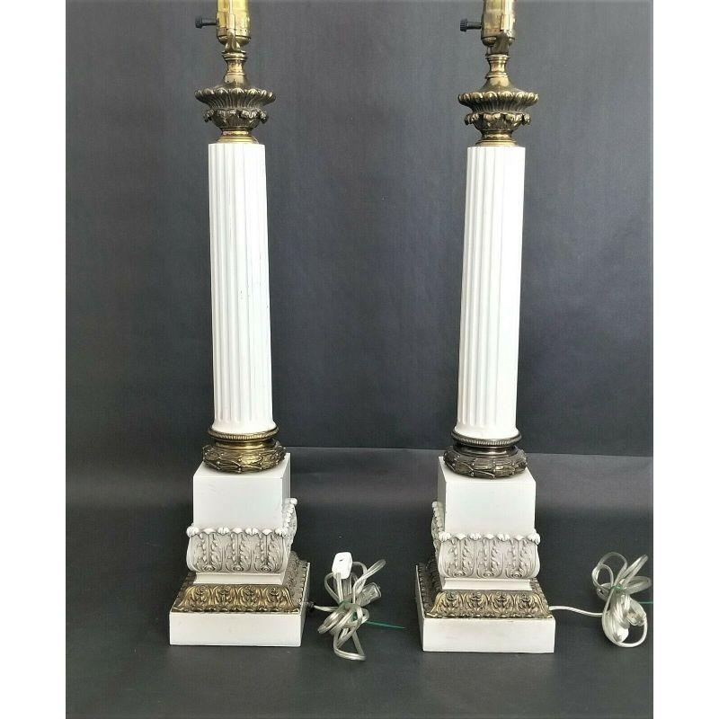 Offering one of our recent palm beach estate fine lighting acquisitions of a
Pair of Vintage Neoclassical Fluted Corinthian Column Enamel & Brass Table Lamps

Brass collar and acanthus leaf design on base. White enamel fluted columns and white