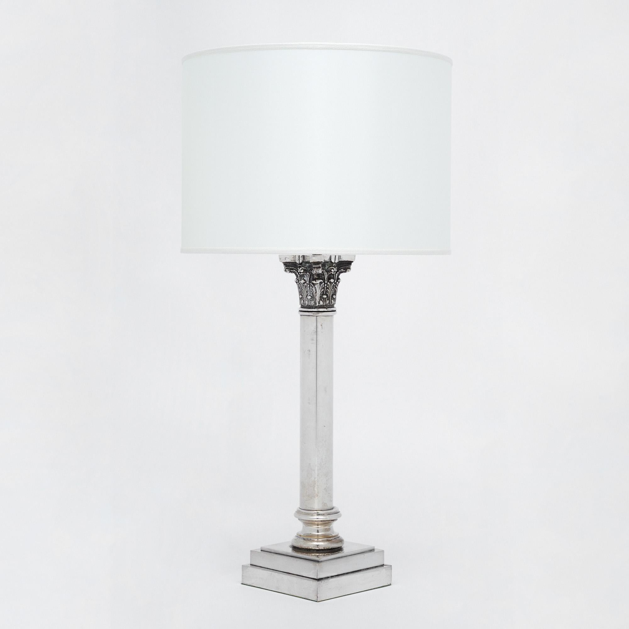 Neoclassical lamp from France made of silver plate over brass. This piece boasts the design details of a Roman Corinthian column. It has been newly wired to US standards and is in very nice antique condition with only minor surface wear consistent