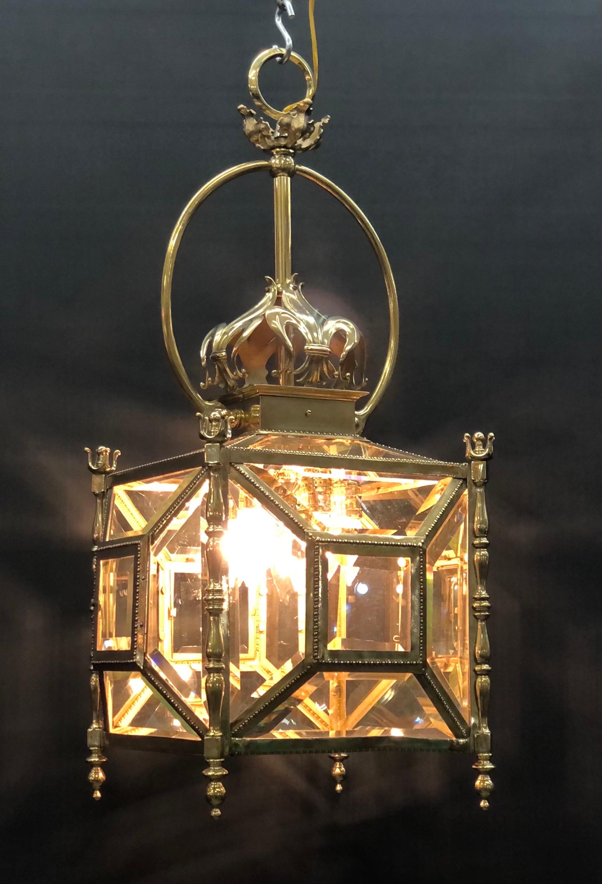 This Neoclassical French Bronze Gasolier Lantern is made of solid cast bronze chased with fine bronze casting still retaining the original geometric beveled glass panels. This Regency Style Lantern has the original bronze Yoke mounted on each side