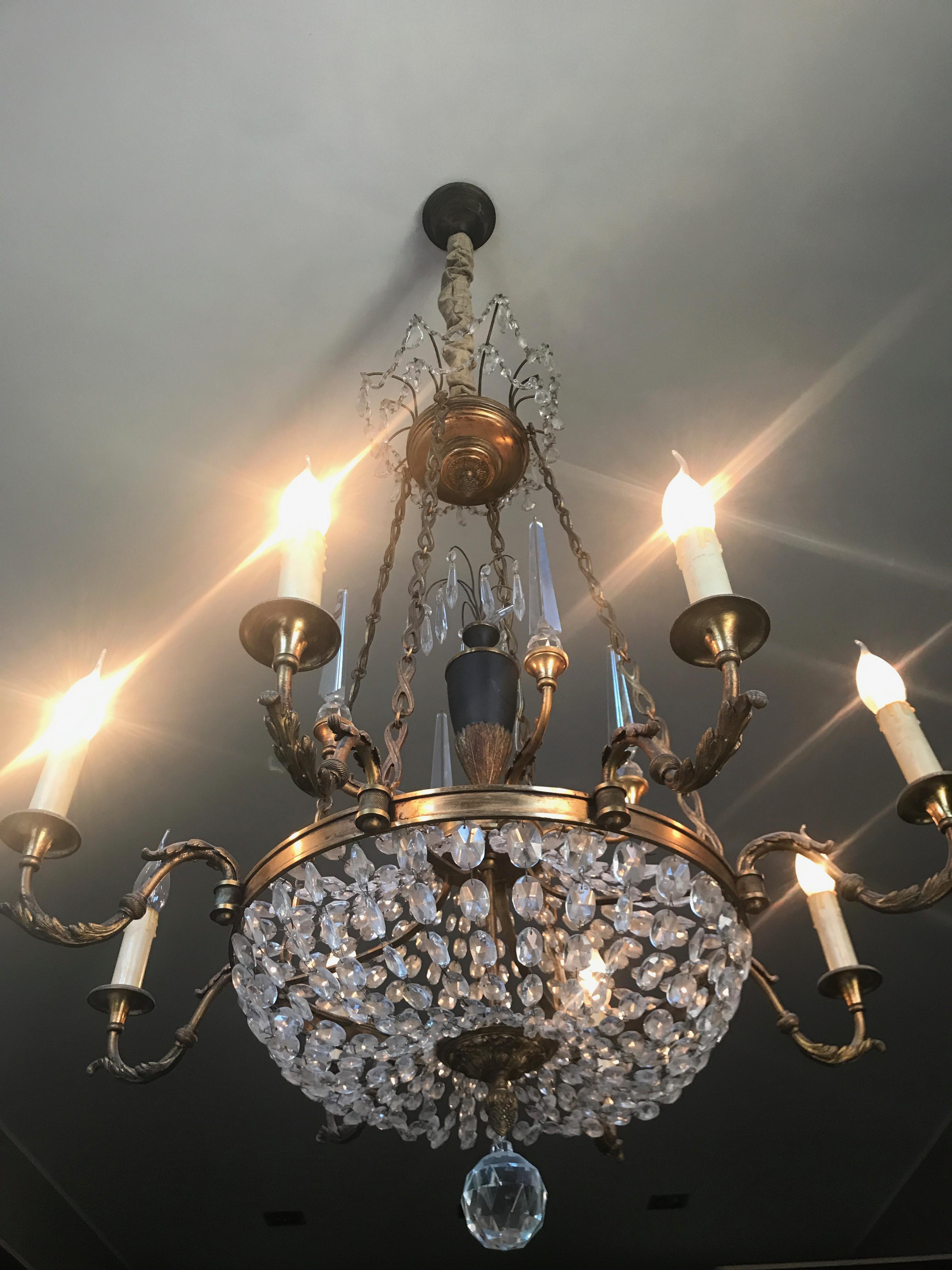 Exceptionally elegant enamel and doré bronze chandelier adorned with cut crystal spires and swags of beads. The stunning solid crystal spires act to reflect the light and cast rainbows on the walls when the day light sun filters thru them. This
