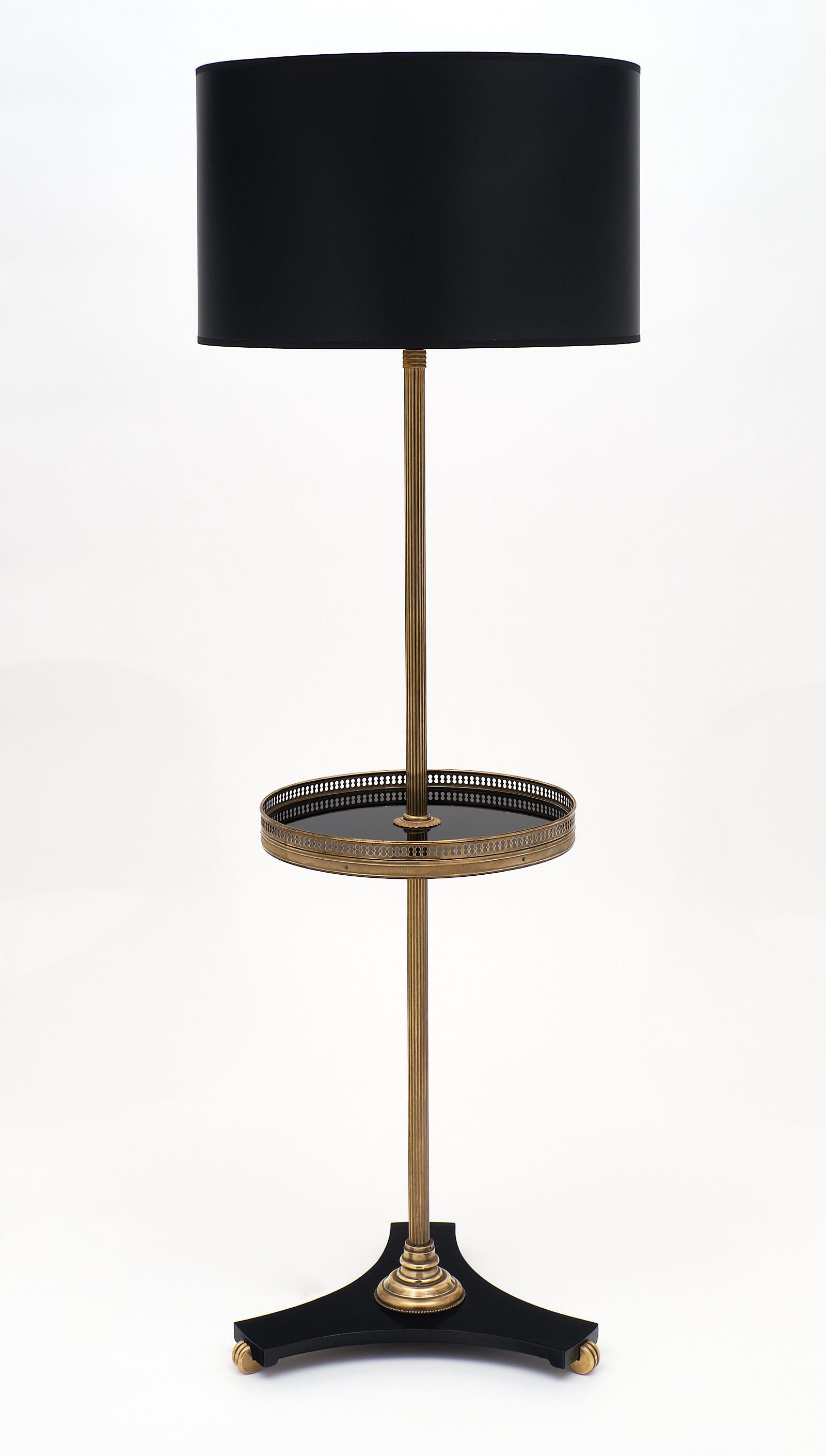 French Neoclassical brass and iron floor lamp from the Art Deco period. This piece has a cobalt black glass tray with a brass gallery and a tripod cast iron base. We love the stability of this fixture. It has been newly wired to fit US standards.