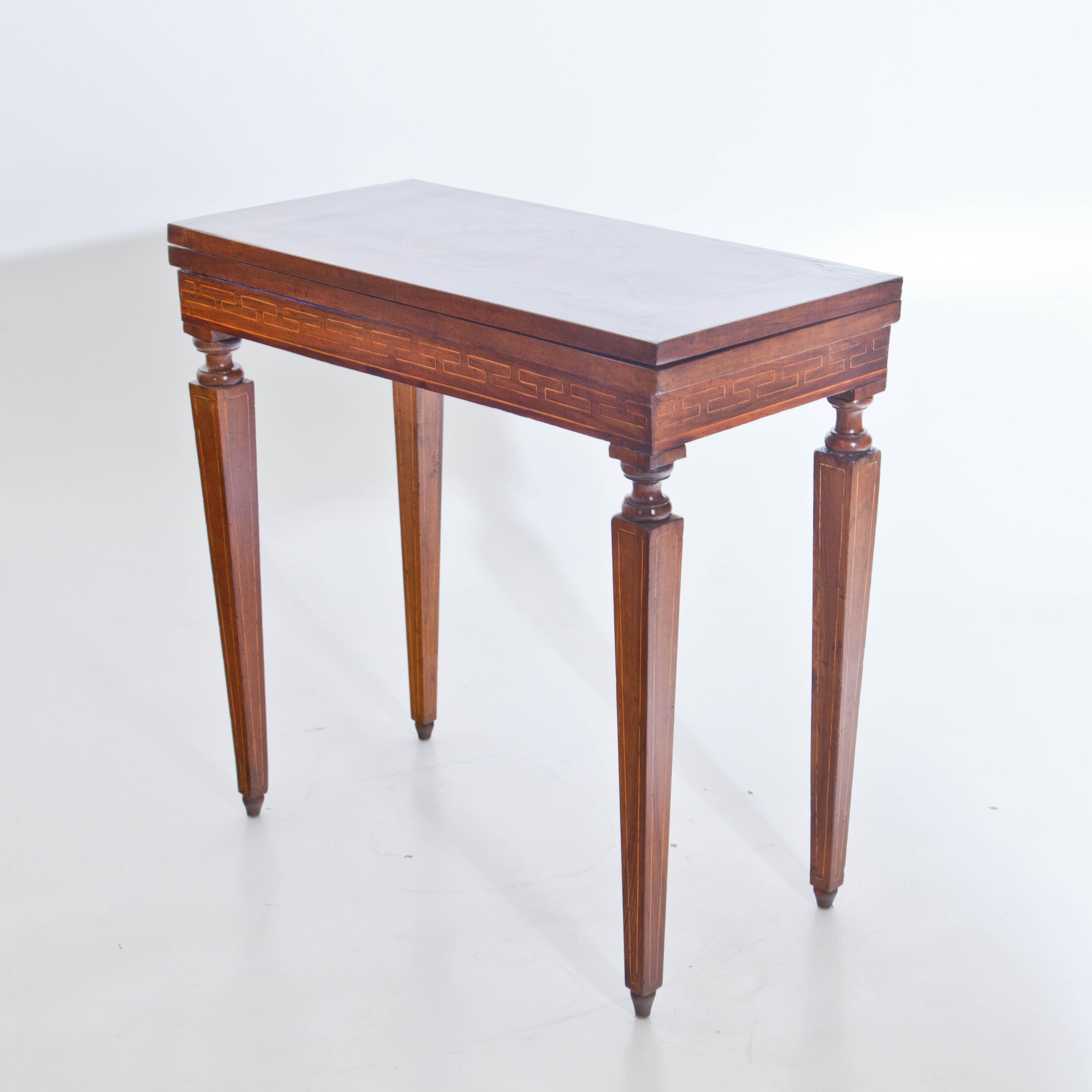 Neoclassical game table or console table on square pointed feet with thread inlays and meander band decoration on the rail. The folding and rotating tabletop is inlaid inside and out. Restored condition, while keeping the old patina.
        