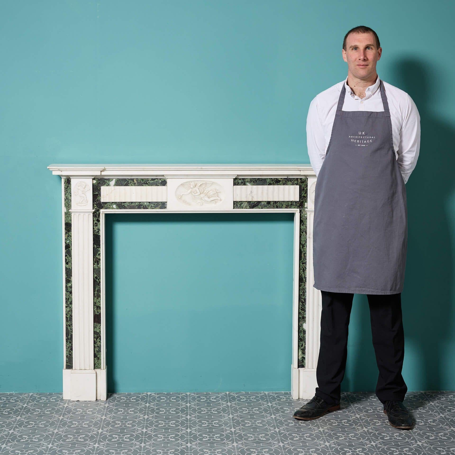 A stunning early 20th century Georgian style white statuary marble and Tinos green marble fireplace decorated in the neoclassical style with a carved angel to the centre tablet and musical putti to the corners.

Though this marble fire surround