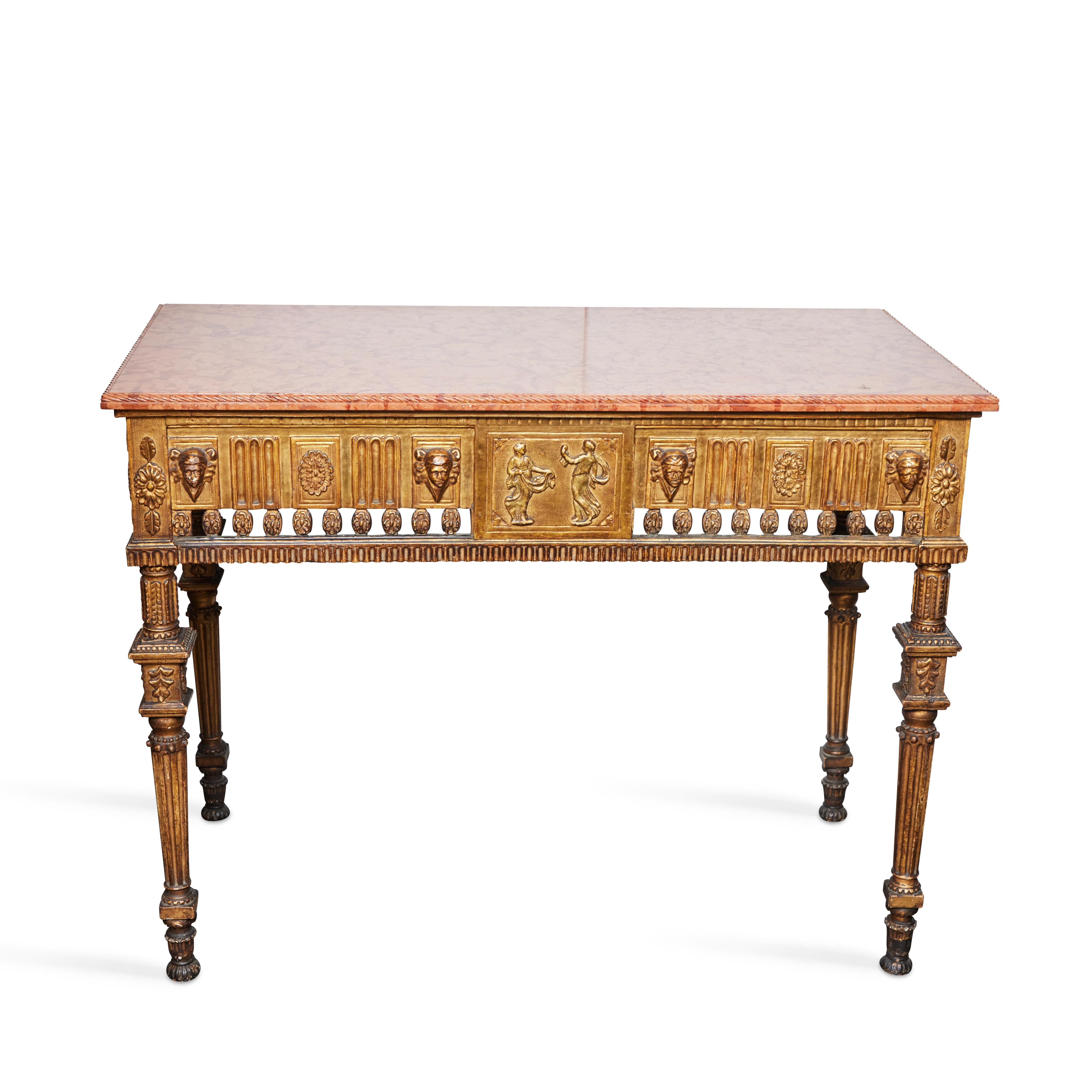 Neoclassical hand carved, gilt wood console with a polished rouge marble top.   The marble top has a carved molded edge, the frieze relief is carved with masks and rosettes and a pierced border of rosettes, flanking a central panel with a pair of