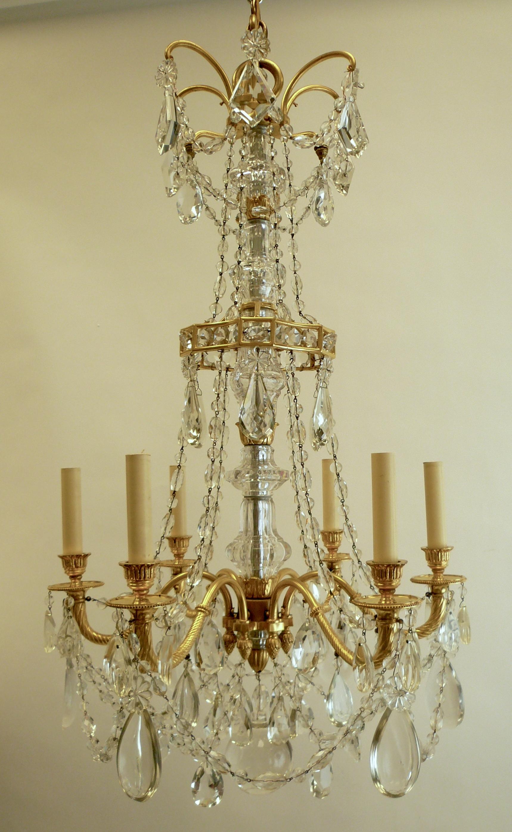 Ce lustre à six lumières signé Caldwell est fait de bronze doré finement détaillé et suspendu avec des guirlandes de chaînes de perles à facettes et des prismes en cristal taillé. Il a été récemment recâblé et est prêt à être utilisé.