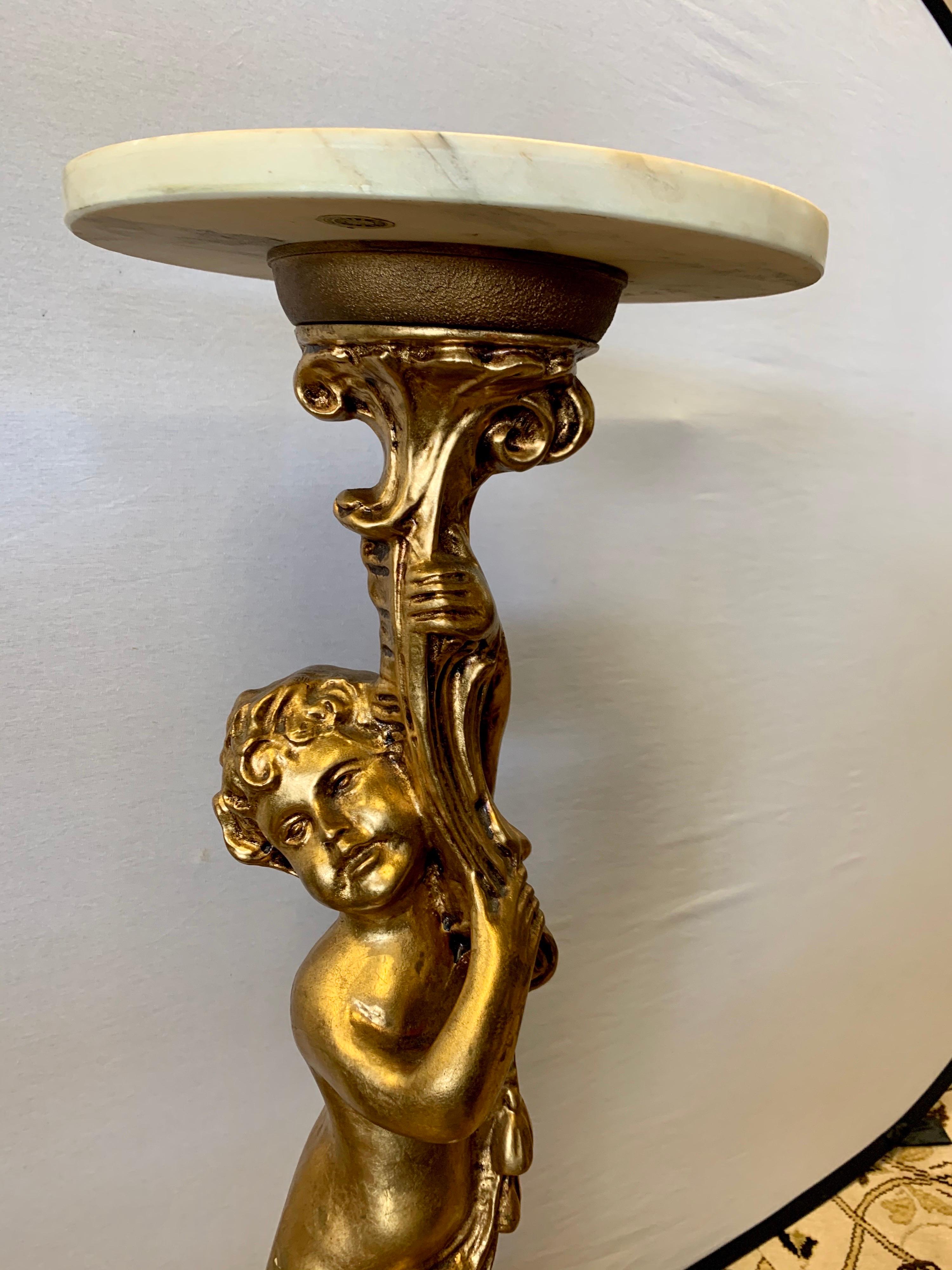 Stunning gilt cherub base pedestal with marble top and bottom. Shows like a beautiful sculpture that functions as a table as well. Made in Italy and hallmarked as such at bottom.