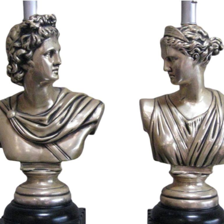 Cette paire de lampes de table de style néoclassique des années 1950 présente des bustes de dieux grecs montés sur la moitié inférieure d'une colonne dorique laquée. Les personnages sont habilement sculptés dans le bois et finis avec une riche laque