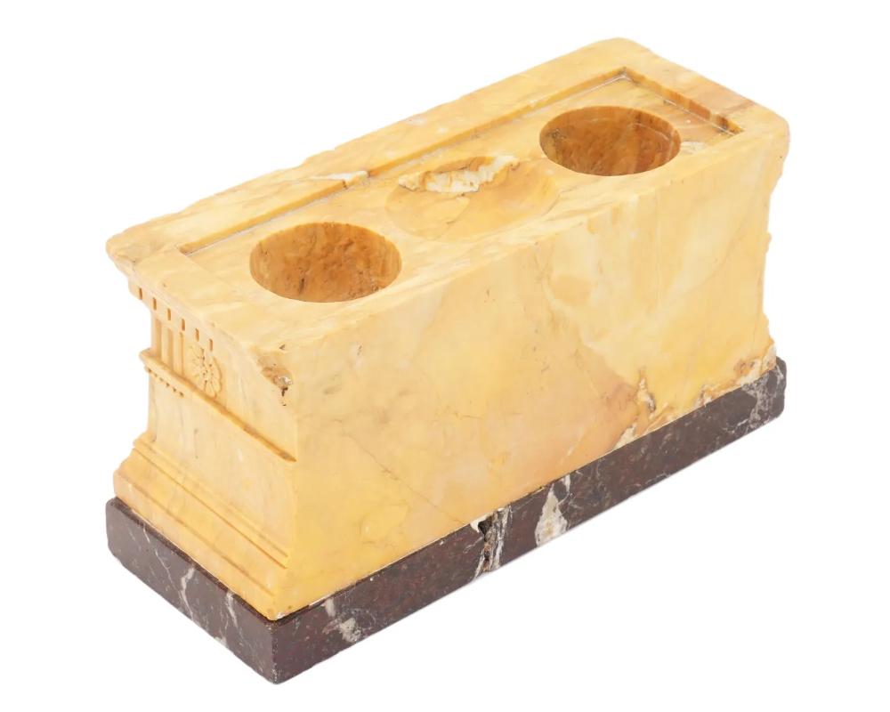 A Neoclassical carved yellow sienna marble inkwell. The item represents a miniature sarcophagus, the tomb of Lucius Cornelius Scipio Barbatus, erected around 150 BC, now in the collection of the Vatican Museum. The inkwell is mounted on a brown