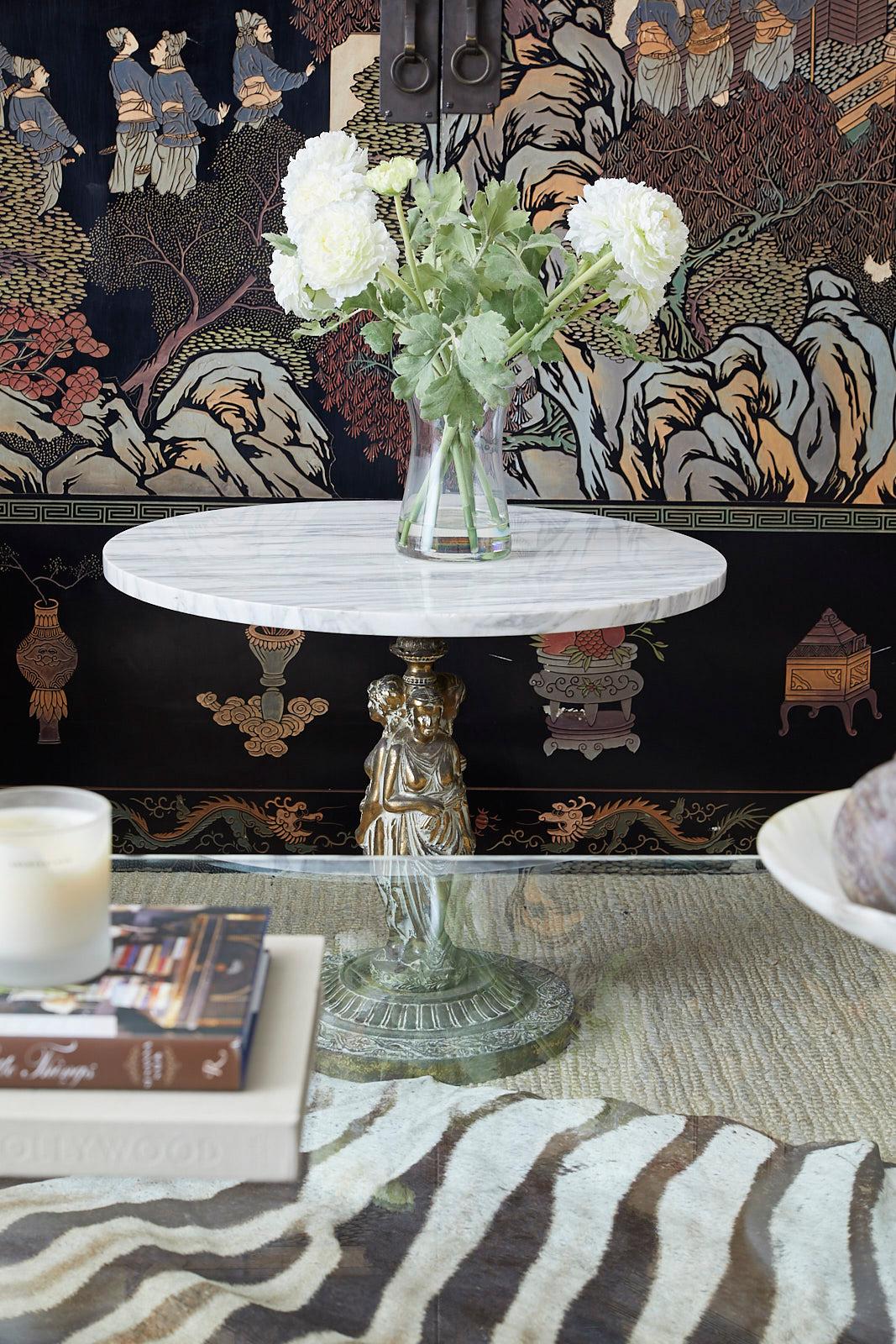 Captivating neoclassical drink table featuring a Grand Tour style brass pedestal base. The pedestal having a Greco-roman figural statue of three graces in flowing robes standing on a round plinth topped with a round slab of Italian Carrara marble