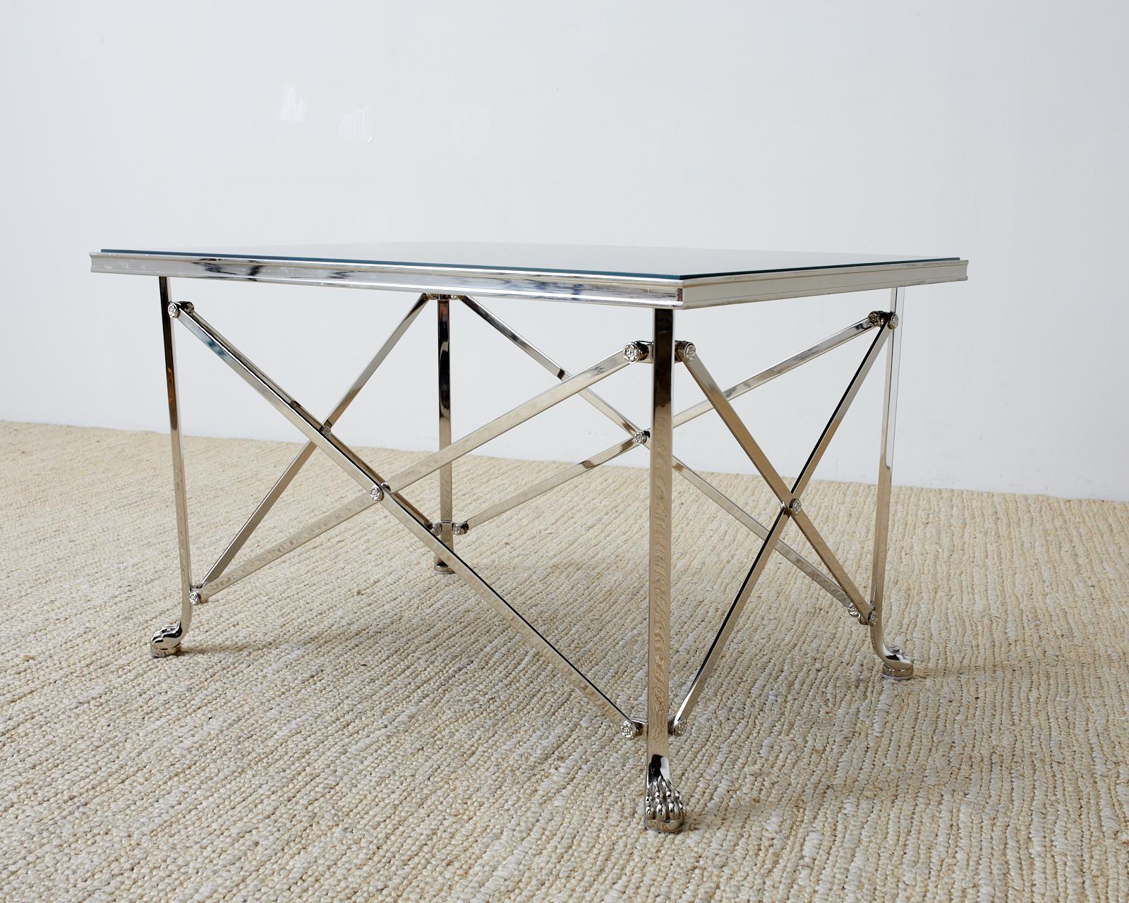 Fantastic coffee cocktail table featuring a black glass top supported by a nickel plated Campaign style base. Made in the Roman neoclassical or Grand Tour taste. The base has a high polish finish with solid construction and superior craftsmanship