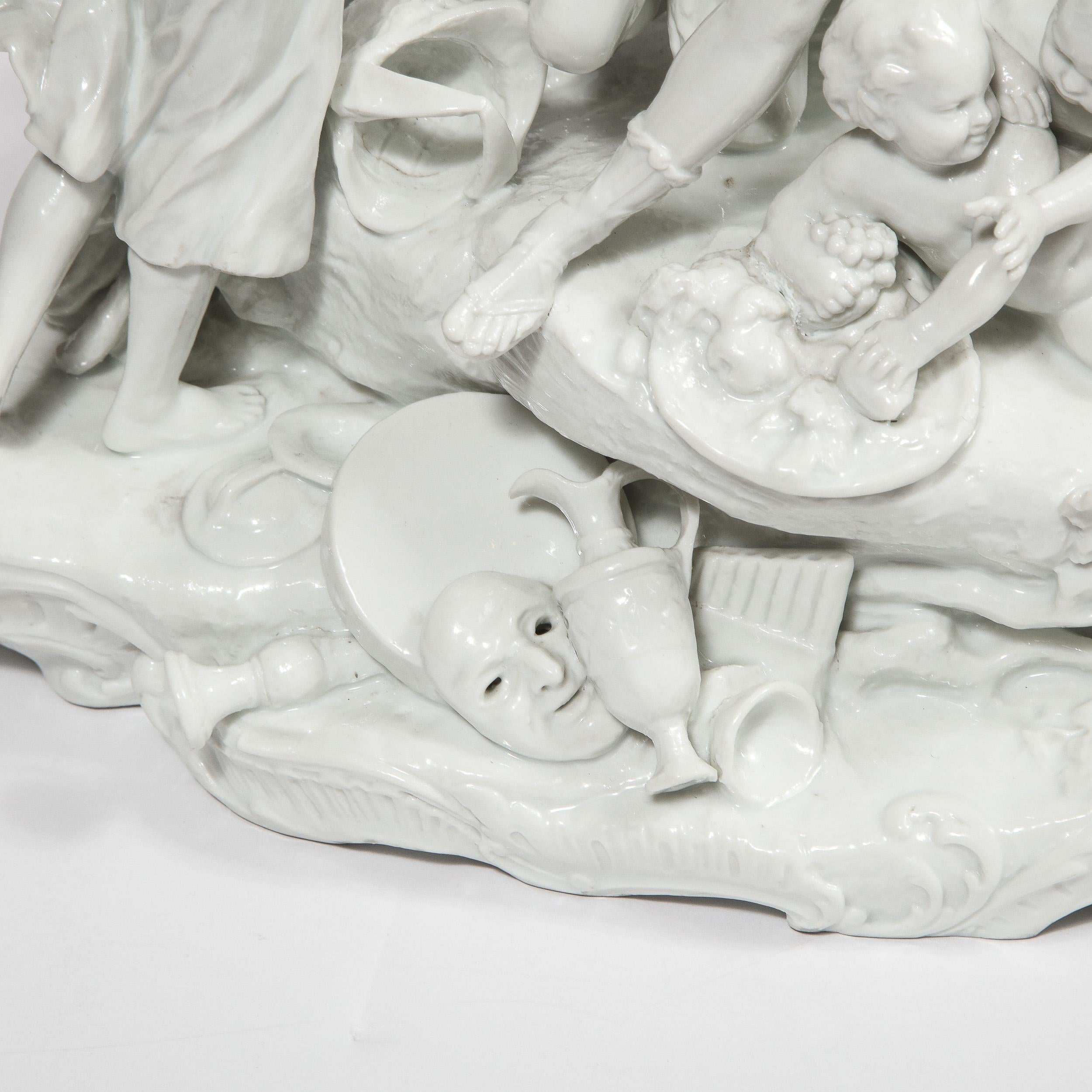 Cette sculpture néoclassique moderniste et raffinée a été réalisée en Allemagne. La pièce représente une bacchanale avec des déesses grecques, de jeunes enfants chérubins et même un ours, le tout exécuté en fine porcelaine blanche. Avec son