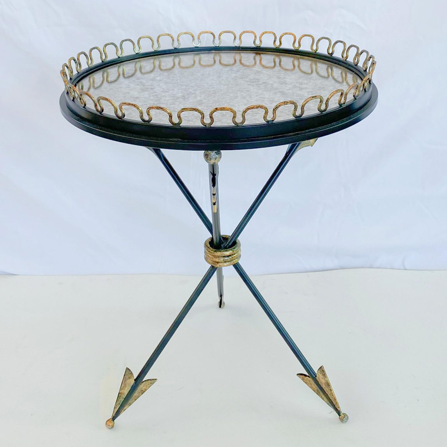 Accent table, of painted and parcel gilt iron, designed by André Arbus; having a round top of antiqued mirror, with a looped, pierced gallery, raised on a trio of feathered arrow legs. 

Stock ID: D1207.