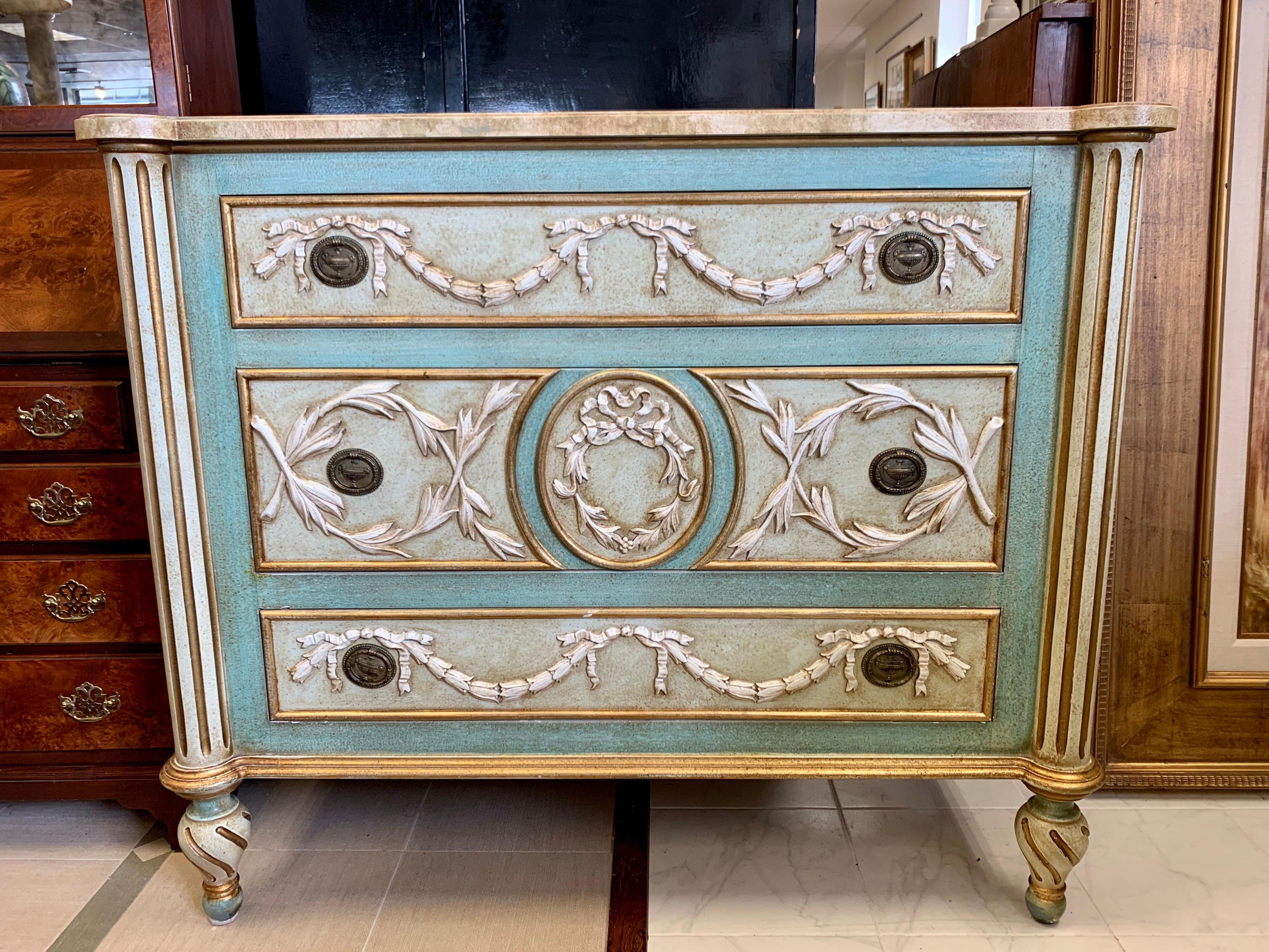 One-of-a-kind hand painted neoclassical dresser with faux marble painted top and raised acanthus leaves with ribbon detail on three sides. Three drawers of varying size and an incredible color scheme of seafoam green gold and cream. The chest is